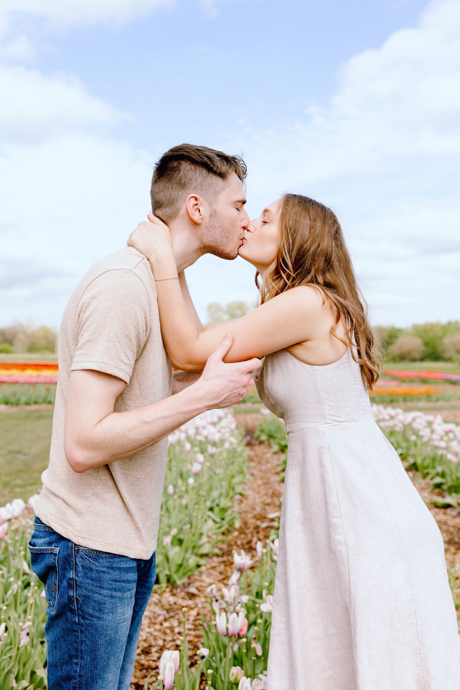 Engaged couple kissing at DeBuck's tulip field spring engagement session in Belleville, MI