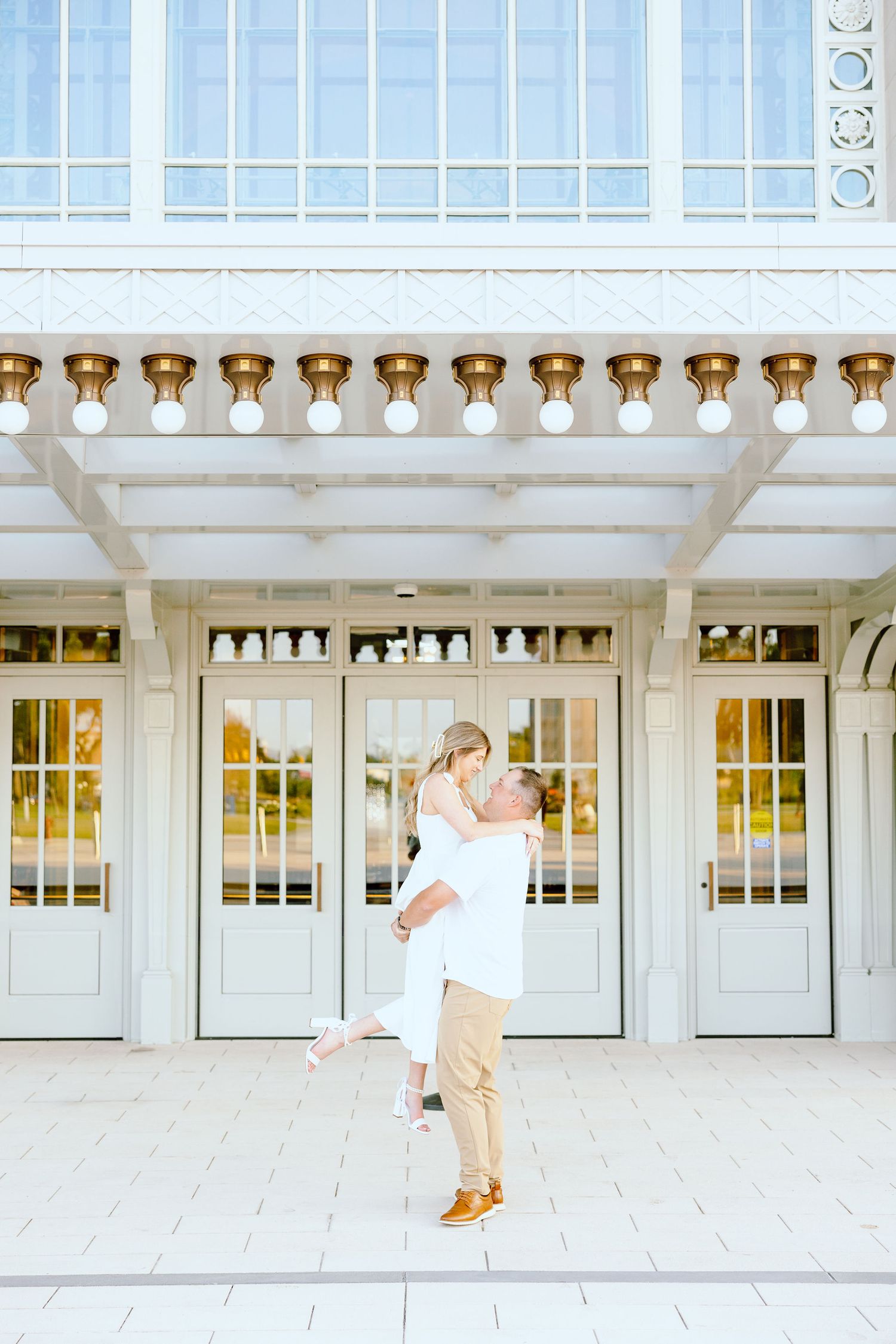 Man lifting woman at Michigan Central Station summer engagement session in Detroit, MI
