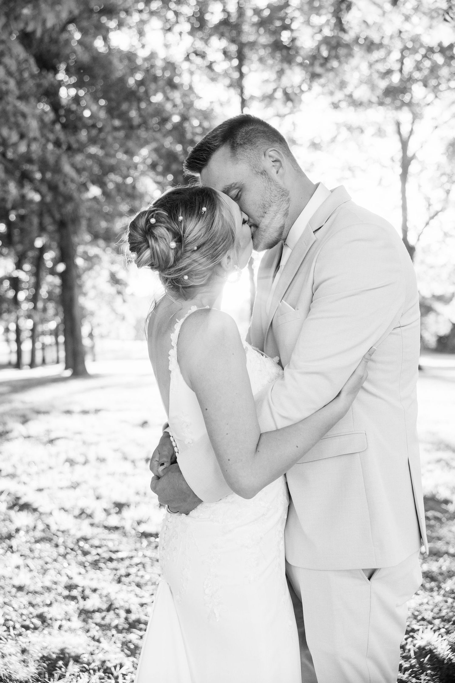 Married couple kissing during golden hour at Lapeer Country Club forest wedding in Michigan