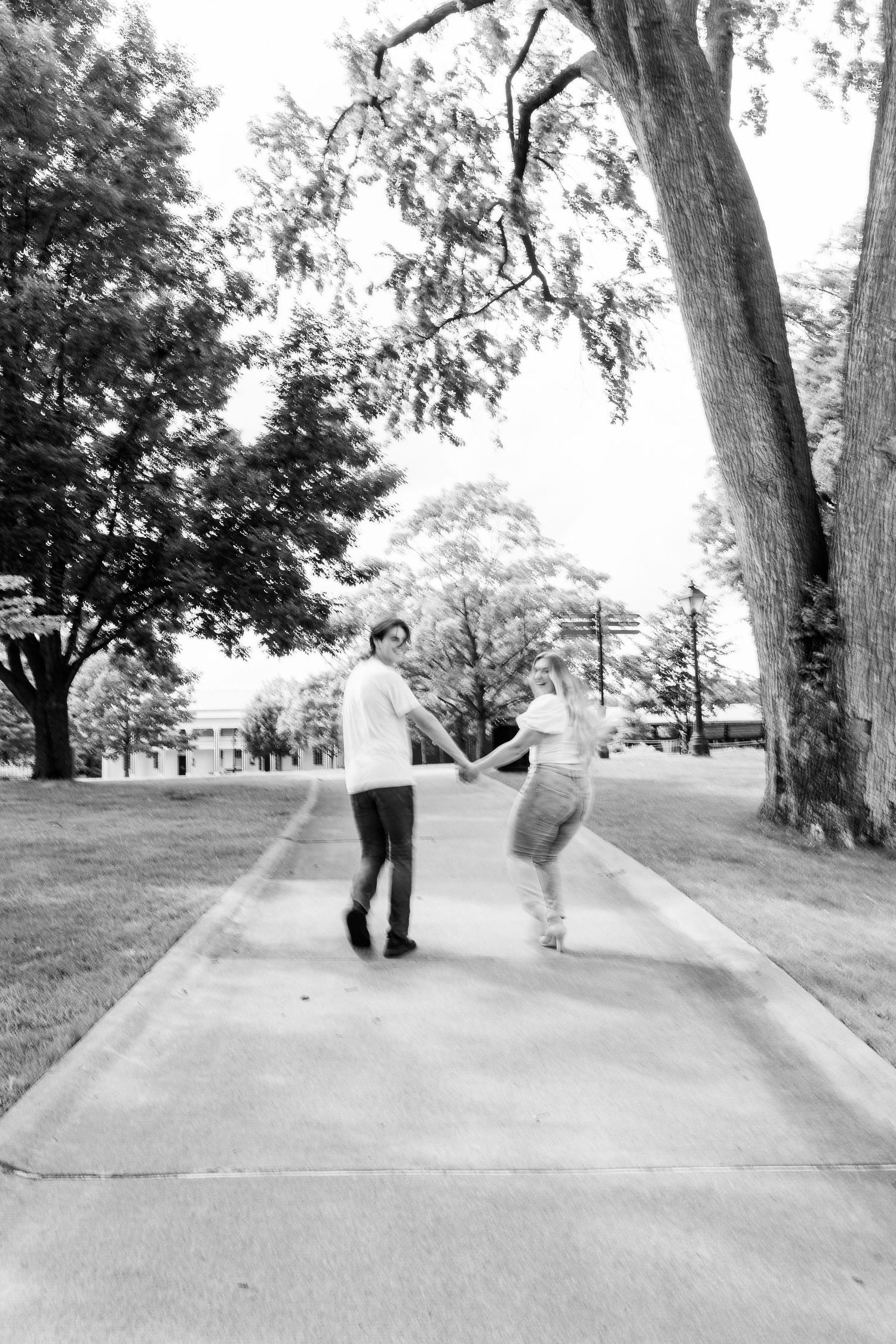 Engaged couple running at Greenfield Village in Dearborn, MI