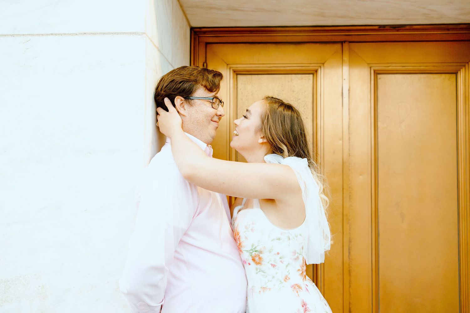 Engaged couple leaning against wall at Belle Isle summer engagement session in Detroit, MI