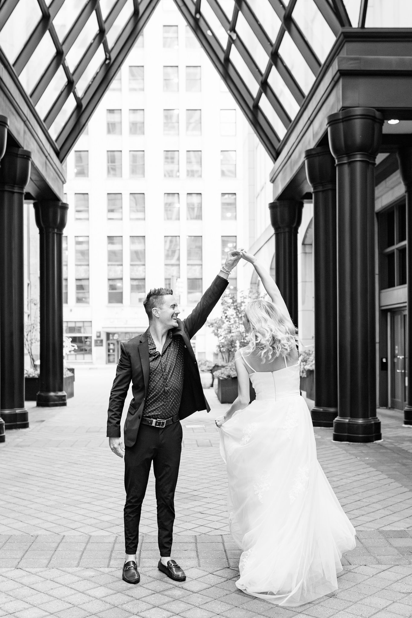 Bride and groom twirling in downtown Detroit, MI elopement