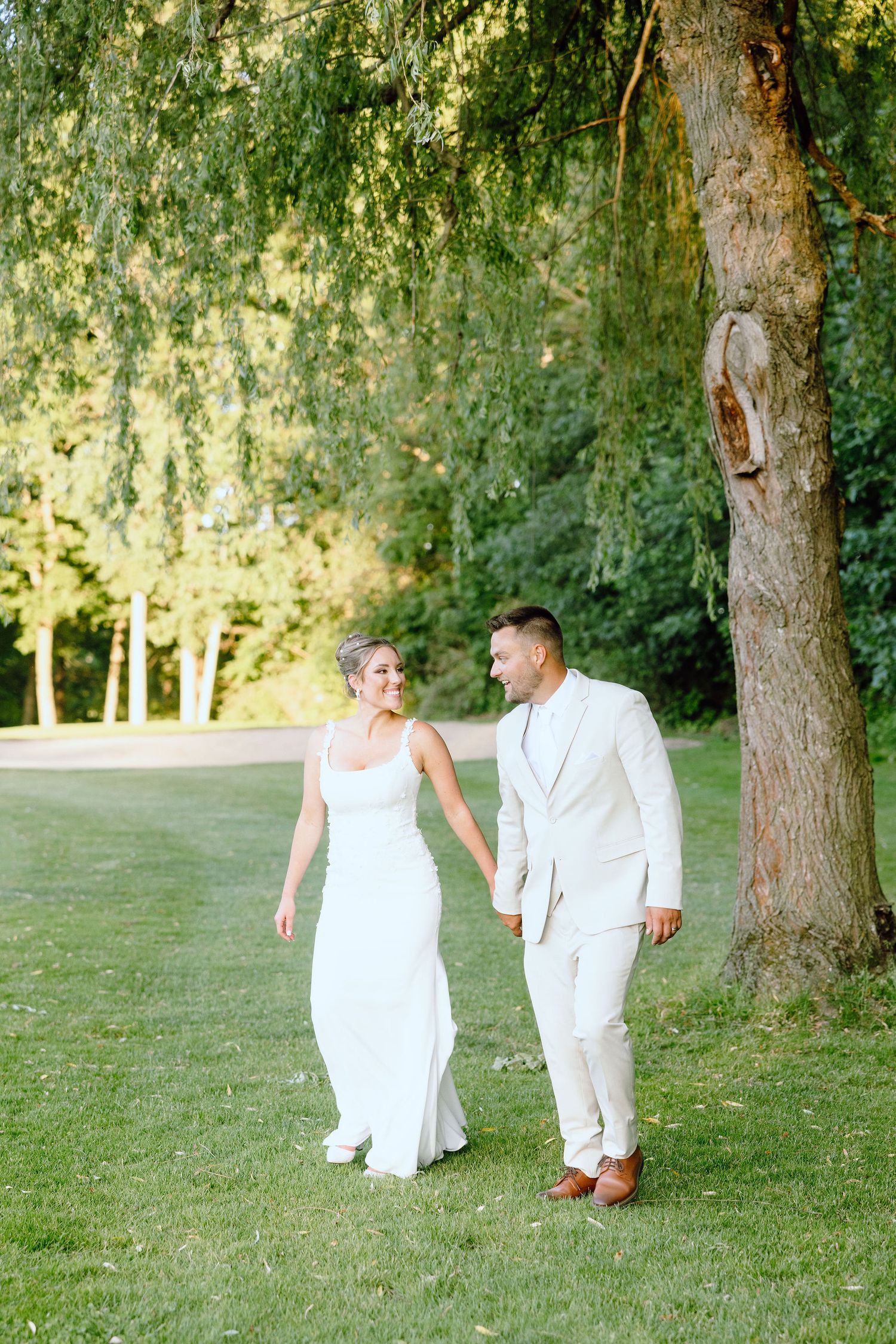 Married couple walking during golden hour at Lapeer Country Club wedding in Michigan