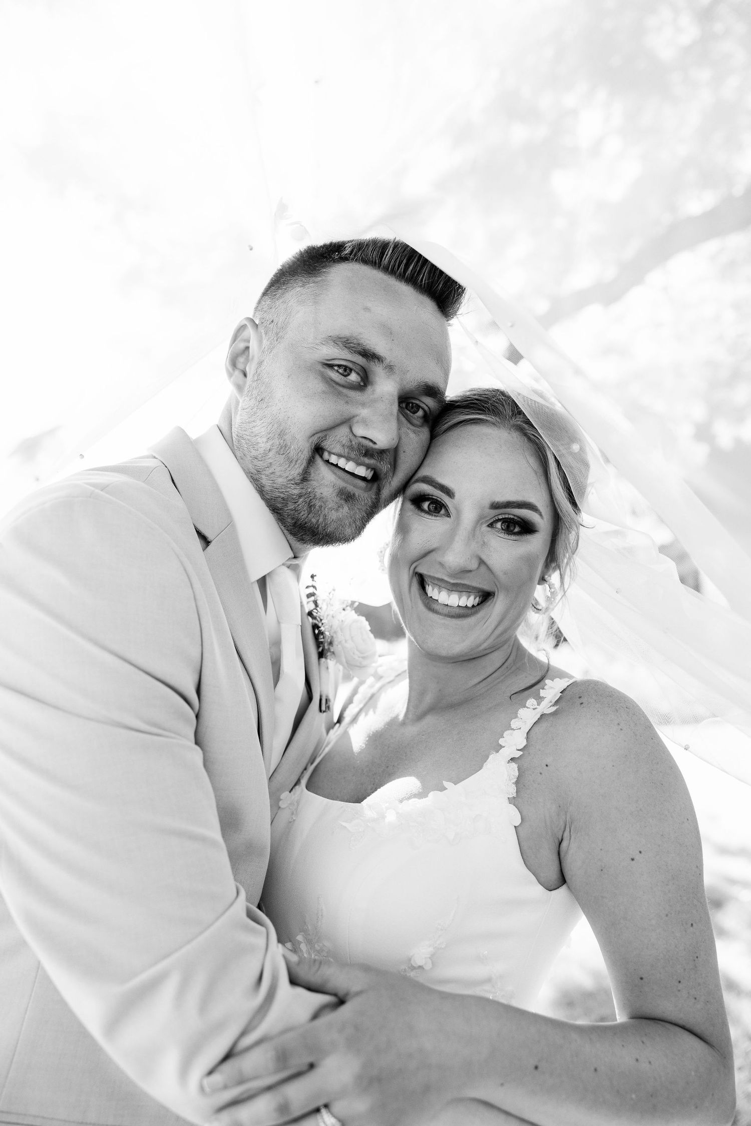 Married couple embracing under veil at Lapeer Country Club, Mi