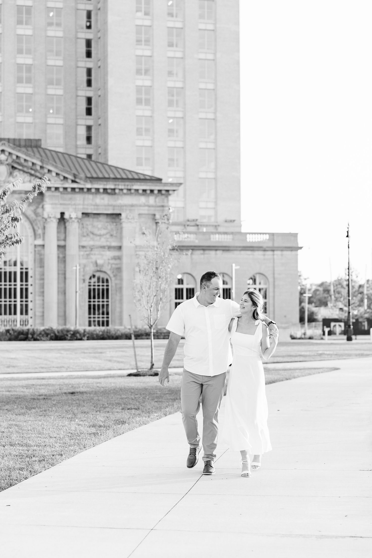 Engaged couple walking and holding hands at Michigan Central Station summer engagement session in Detroit, MI