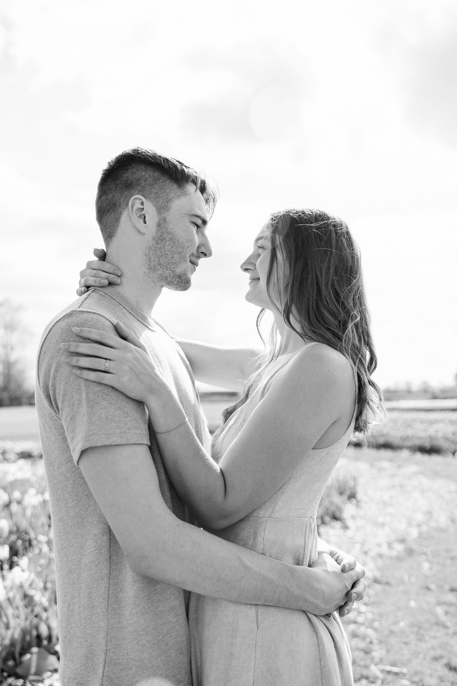 Engaged couple embracing at DeBuck's tulip field spring engagement session in Belleville, MI