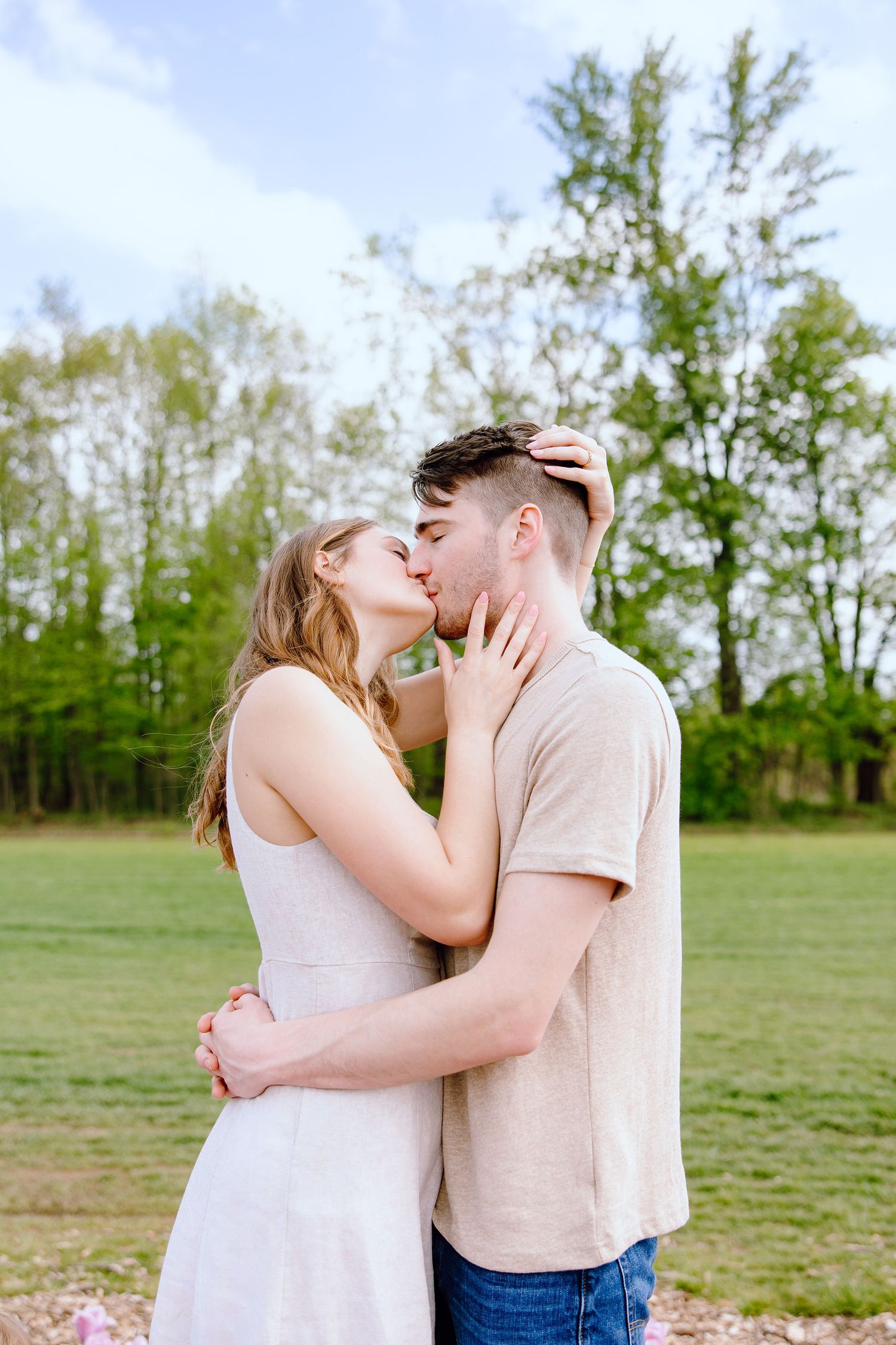 Engaged couple kissing at DeBuck's tulip field spring engagement session in Belleville, MI