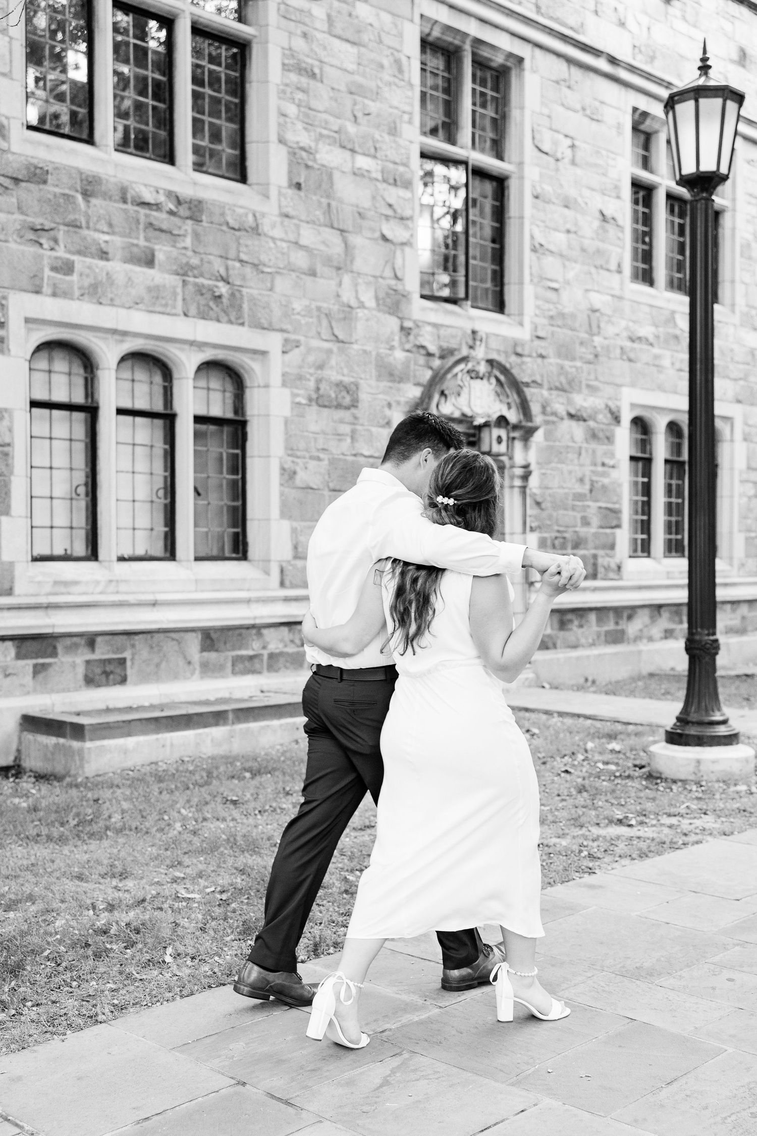 Engaged couple walking and holding hands at the UofM Law Quad engagement session in Ann Arbor, MI