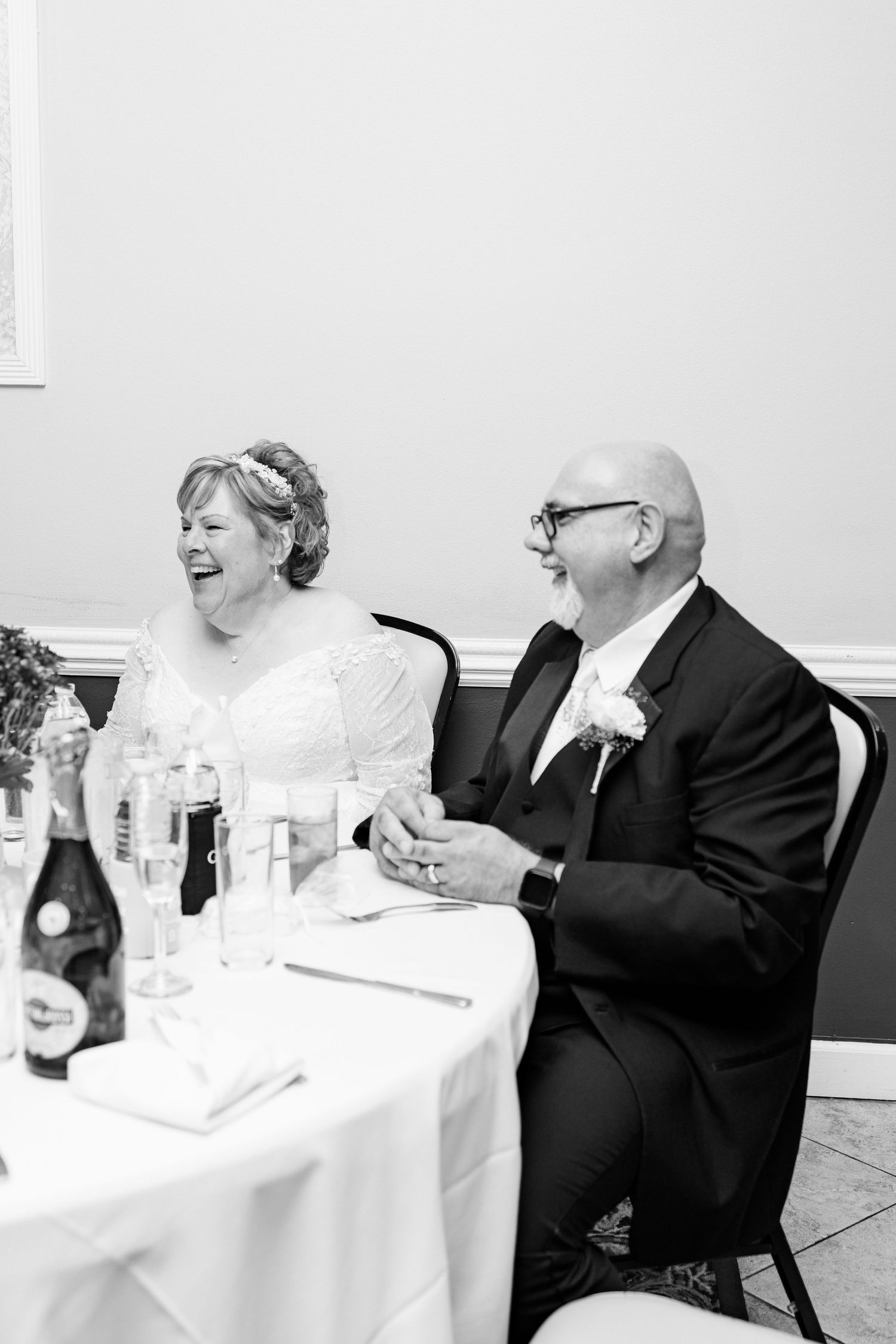 Married couple laughing at reception in Wayne, MI