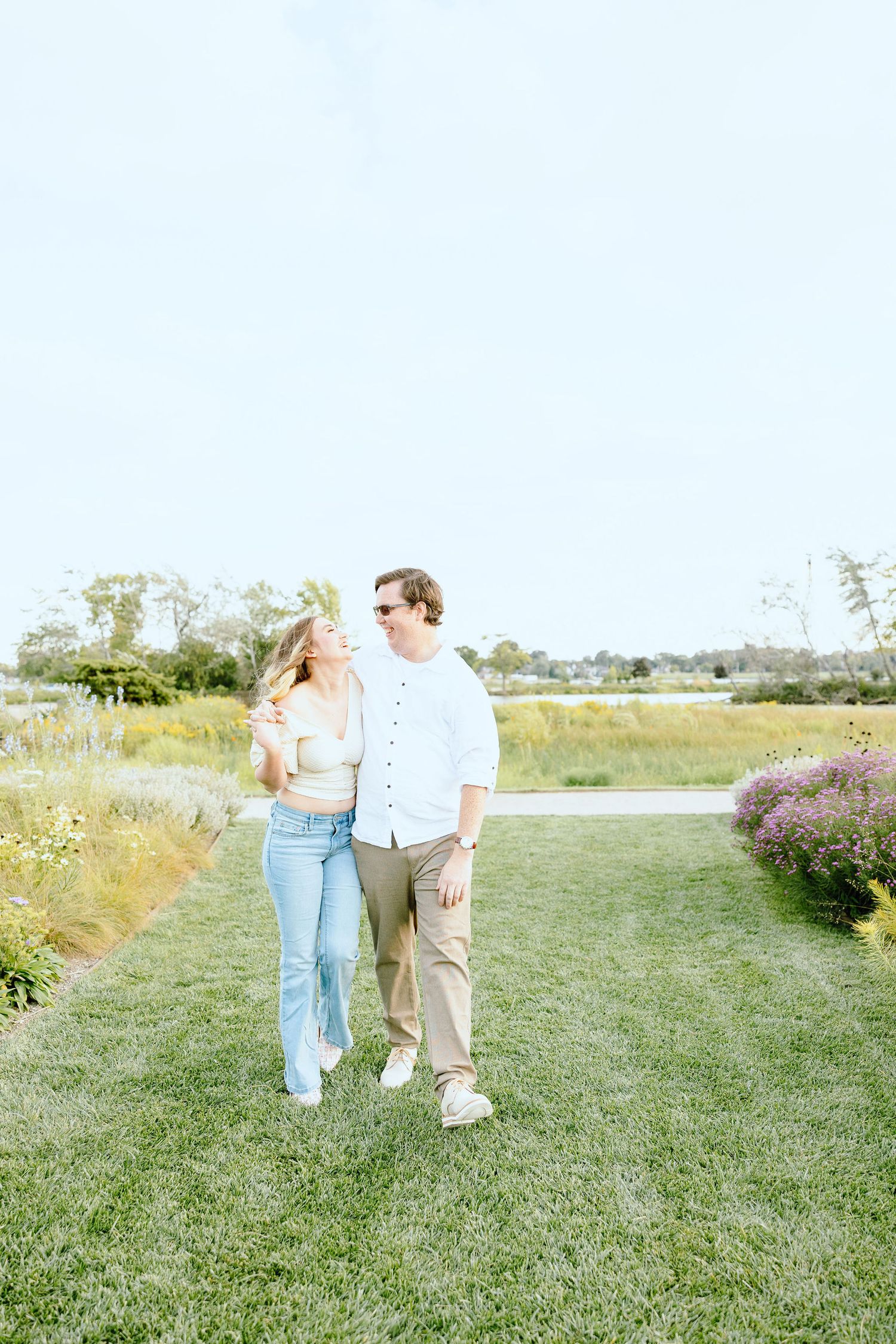 Engaged couple walking and holding hands at Belle Isle summer engagement session in Detroit, MI