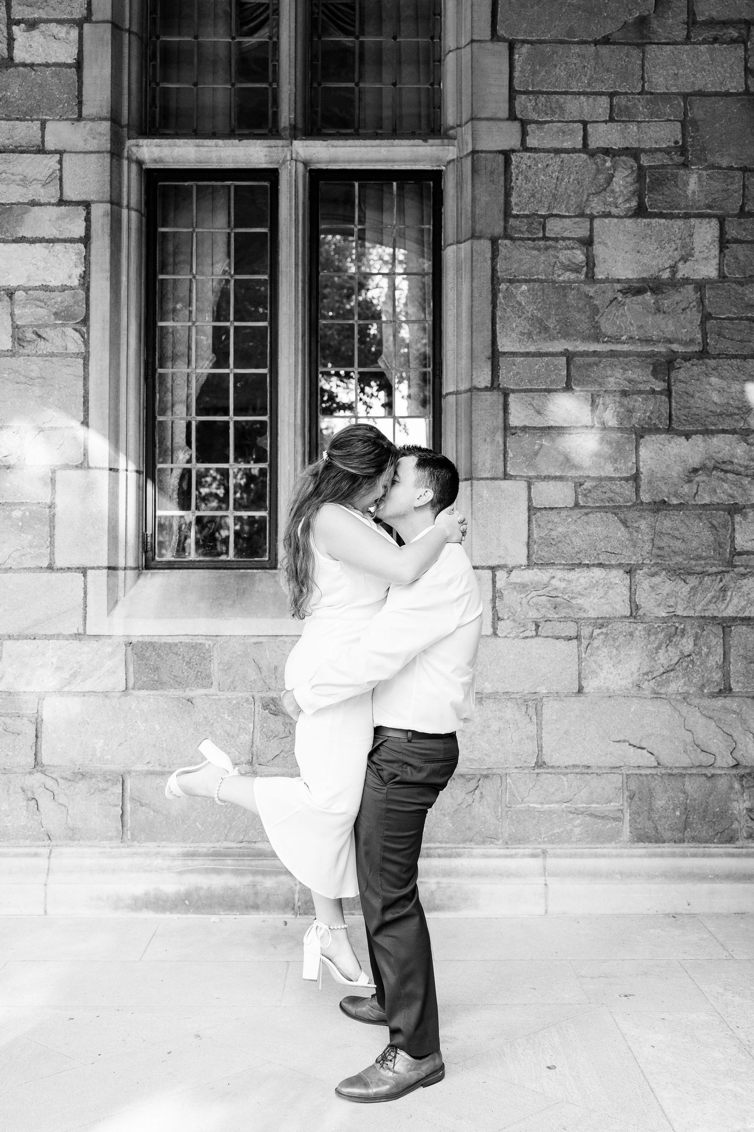 Man lifting woman at the UofM Law Quad engagement session in Ann Arbor, MI