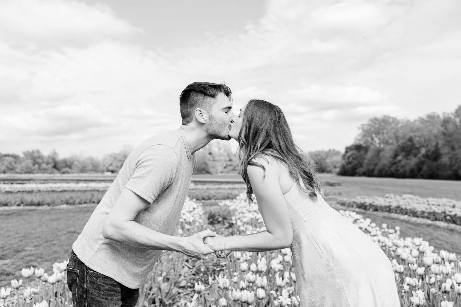 Engaged couple kissing at DeBuck's tulip field spring engagement session in Belleville, MI