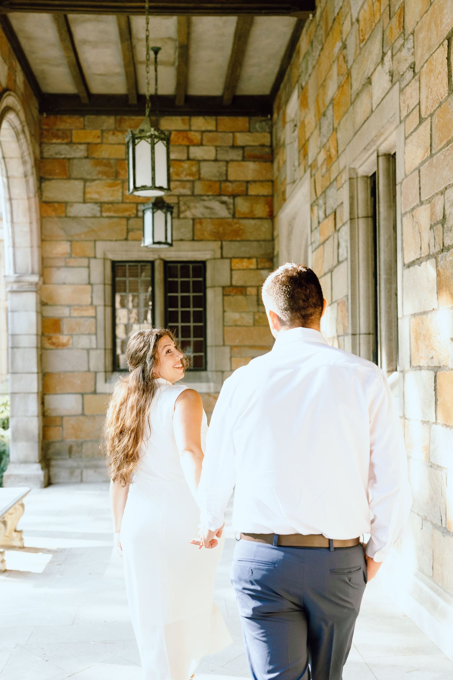 Engaged couple walking and holding hands at the UofM Law Quad engagement session in Ann Arbor, MI