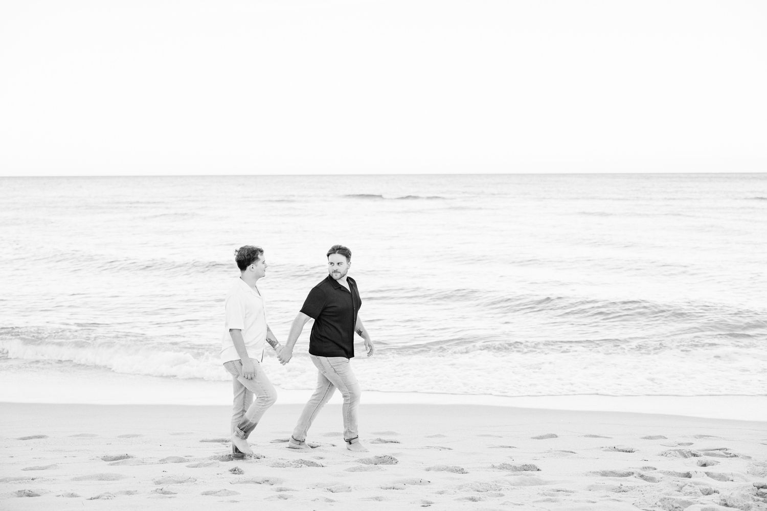 LGBTQ+ couple walking and holding hands on North Miami Beach in Florida