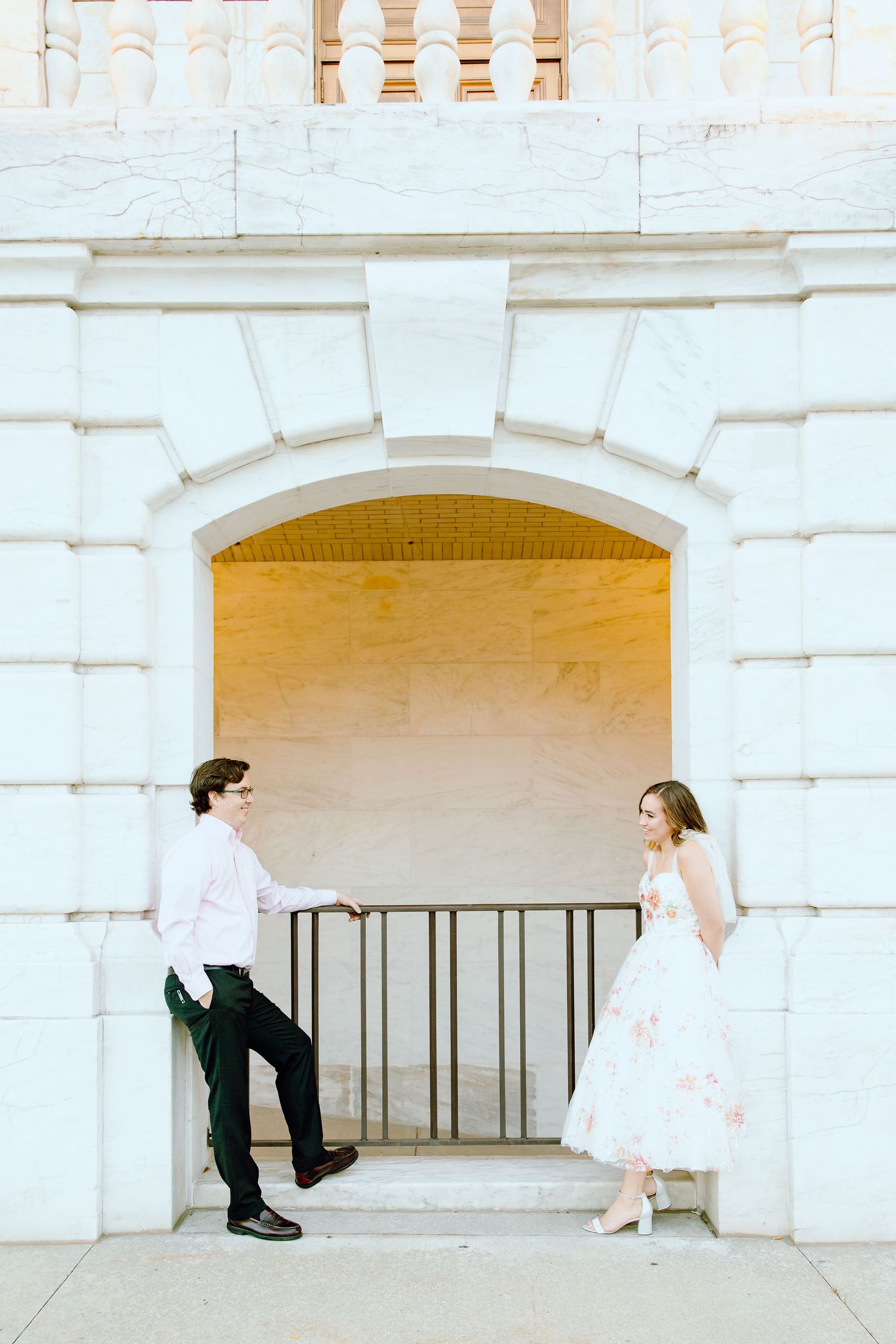 Engaged couple leaning against wall at Belle Isle summer engagement session in Detroit, MI