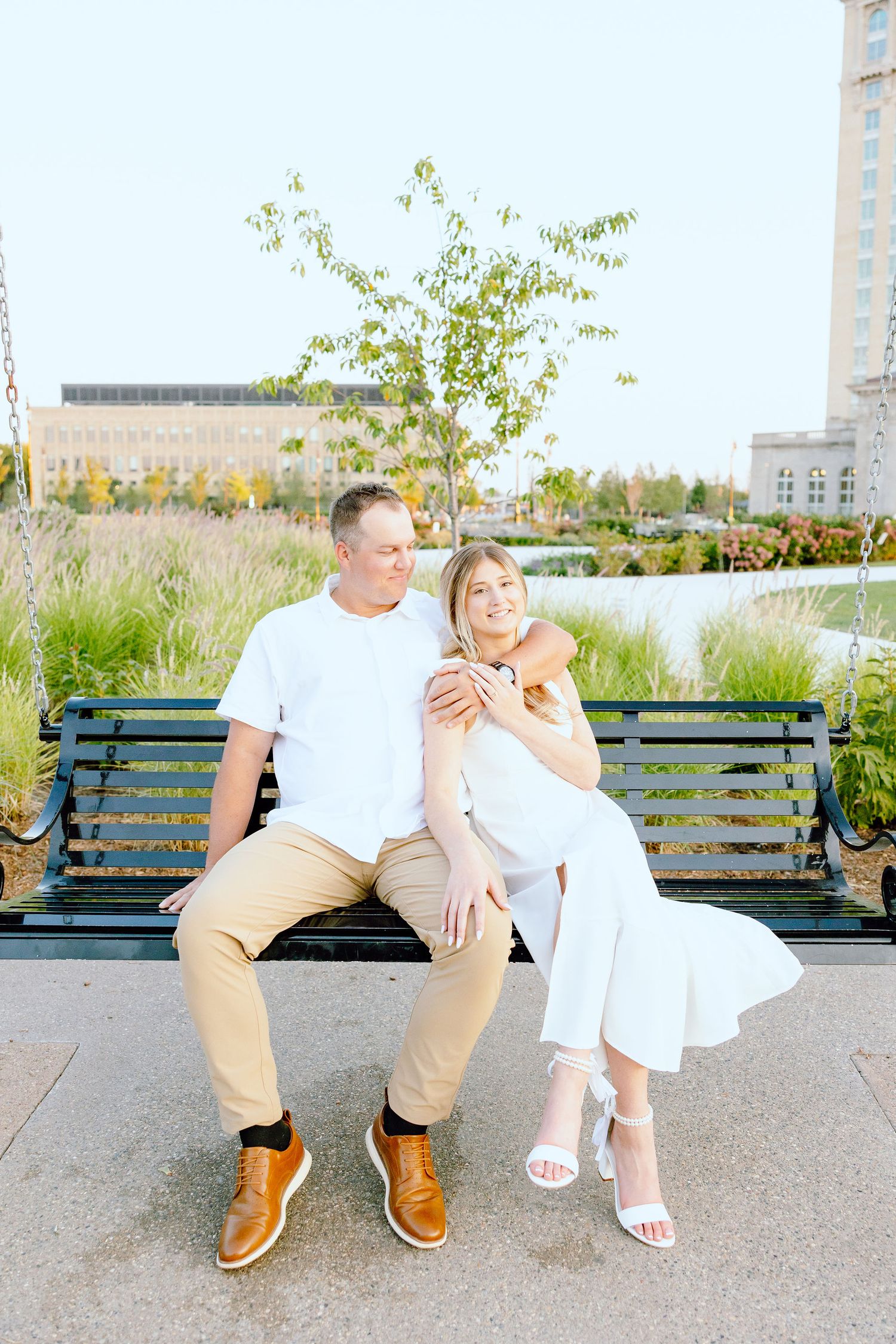 Engaged couple embracing on bench at Michigan Central Station in Detroit, MI