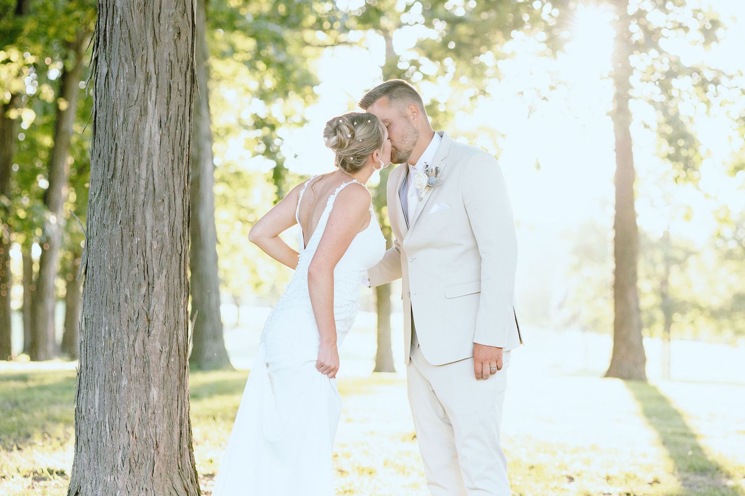 Married couple kissing during golden hour at Lapeer Country Club forest wedding in Michigan