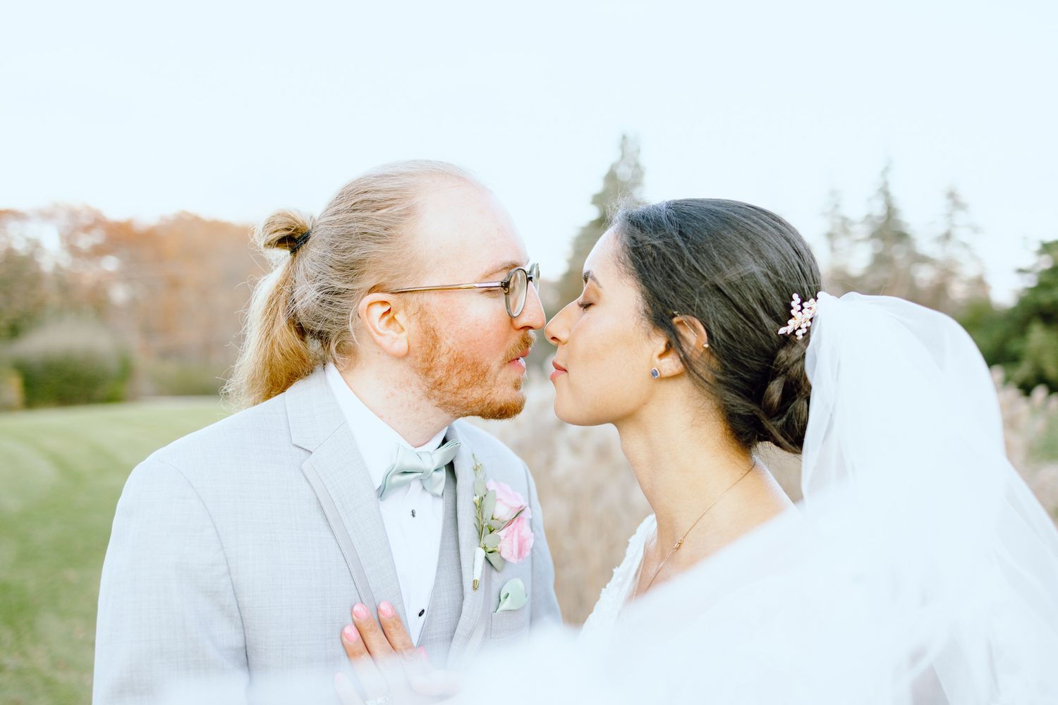Married couple kissing behind veil at Novi church wedding in MI