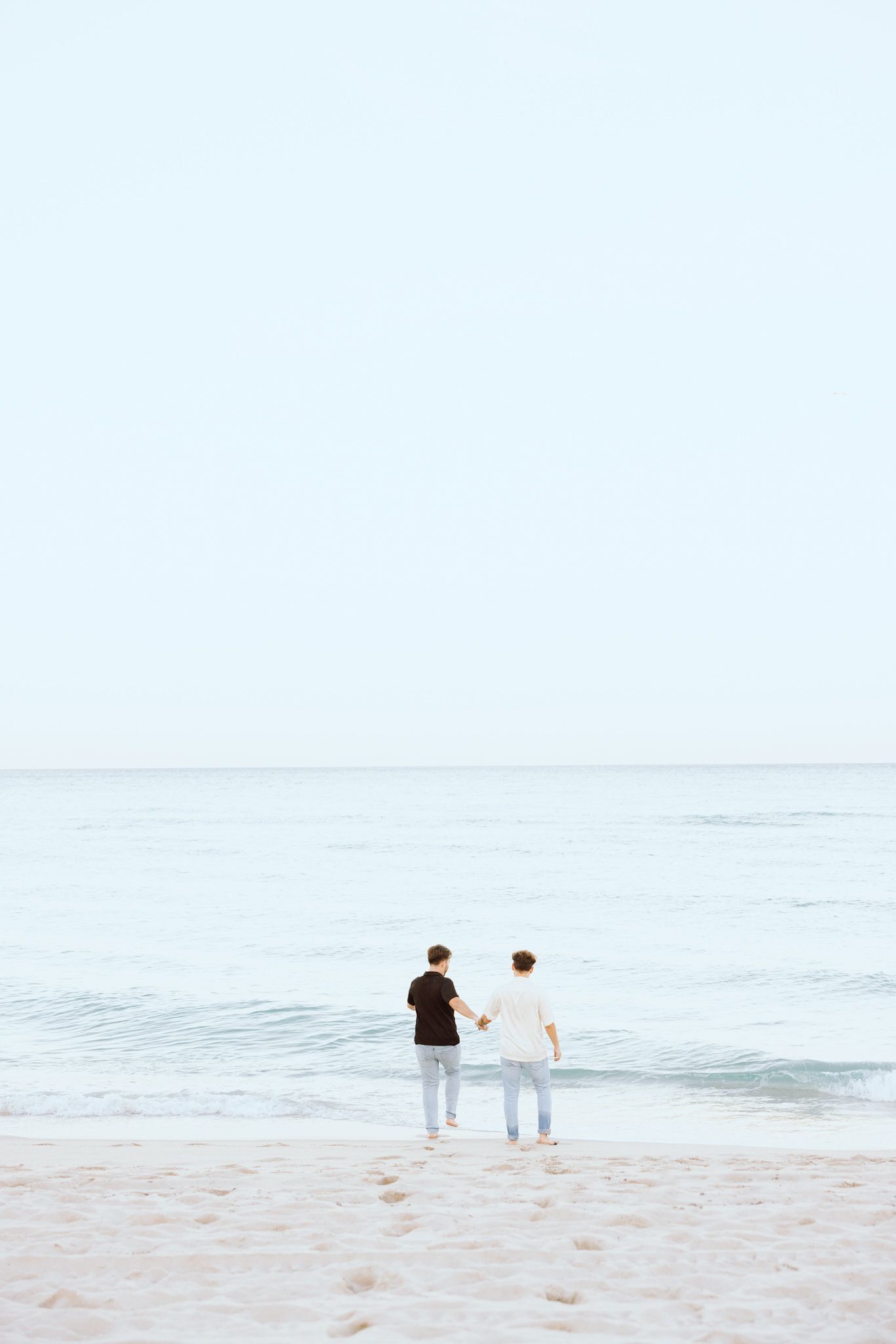 LGBTQ+ couple running and holding hands on North Miami Beach in Florida
