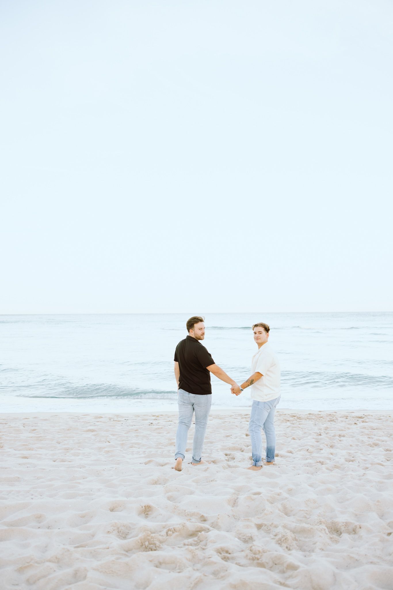 LGBTQ+ couple walking and holding hands on North Miami Beach in Florida