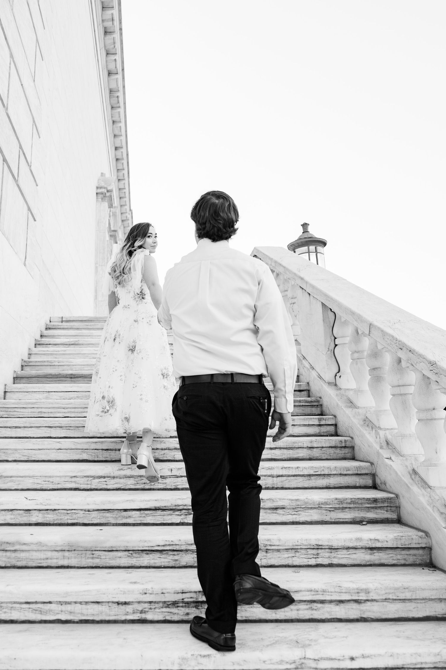Engaged couple walking up stairs at Detroit Institute of Arts in Detroit, MI