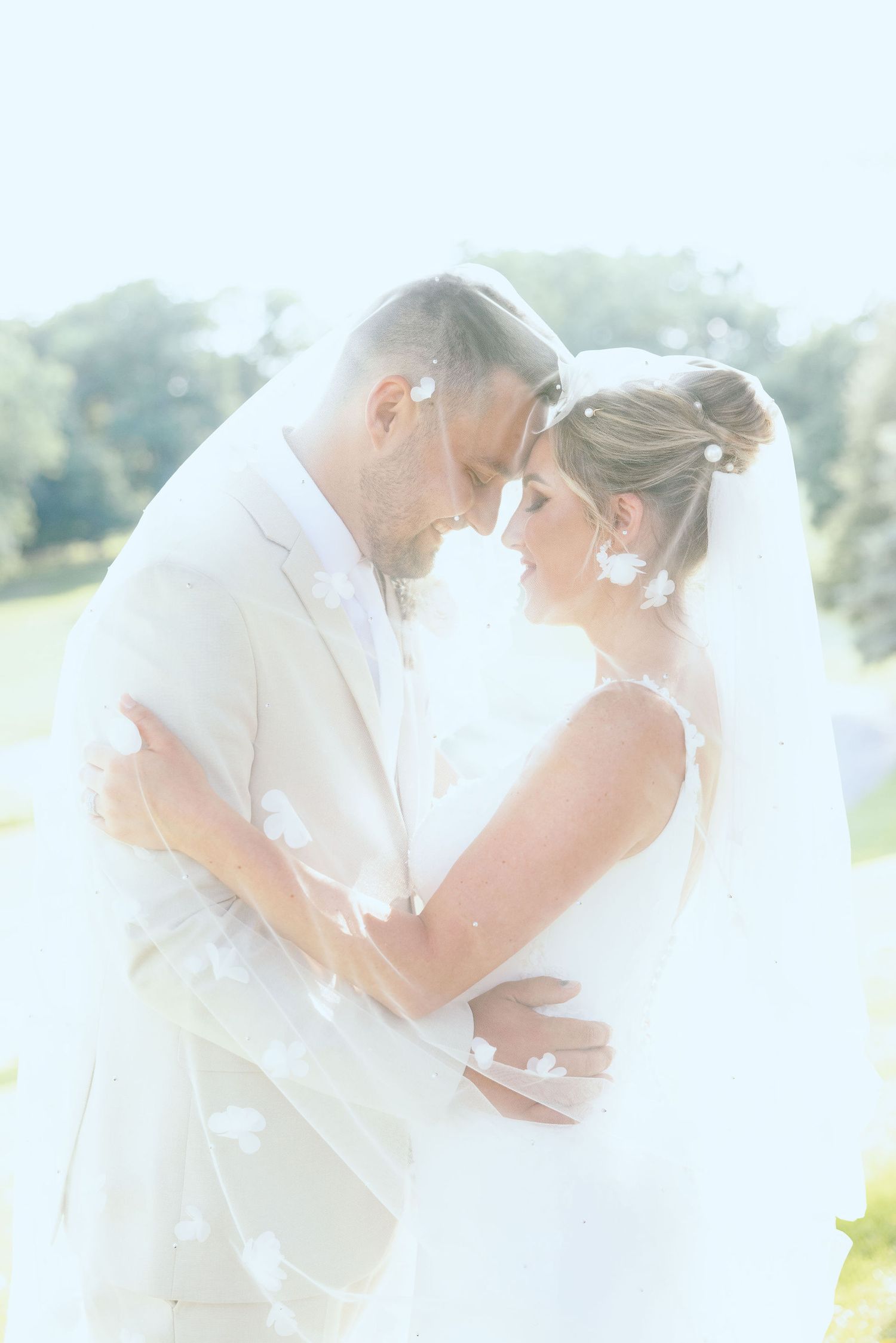 Married couple embracing under veil at Lapeer Country Club wedding in Michigan