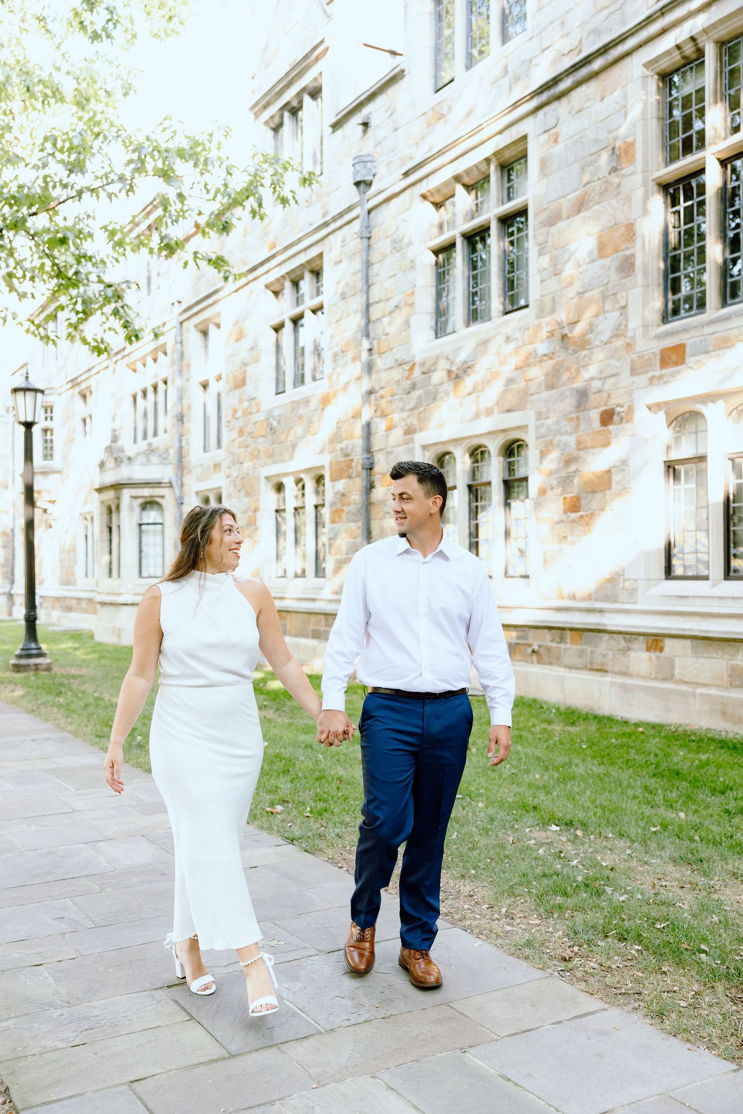 Engaged couple walking and holding hands at the UofM Law Quad engagement session in Ann Arbor, MI