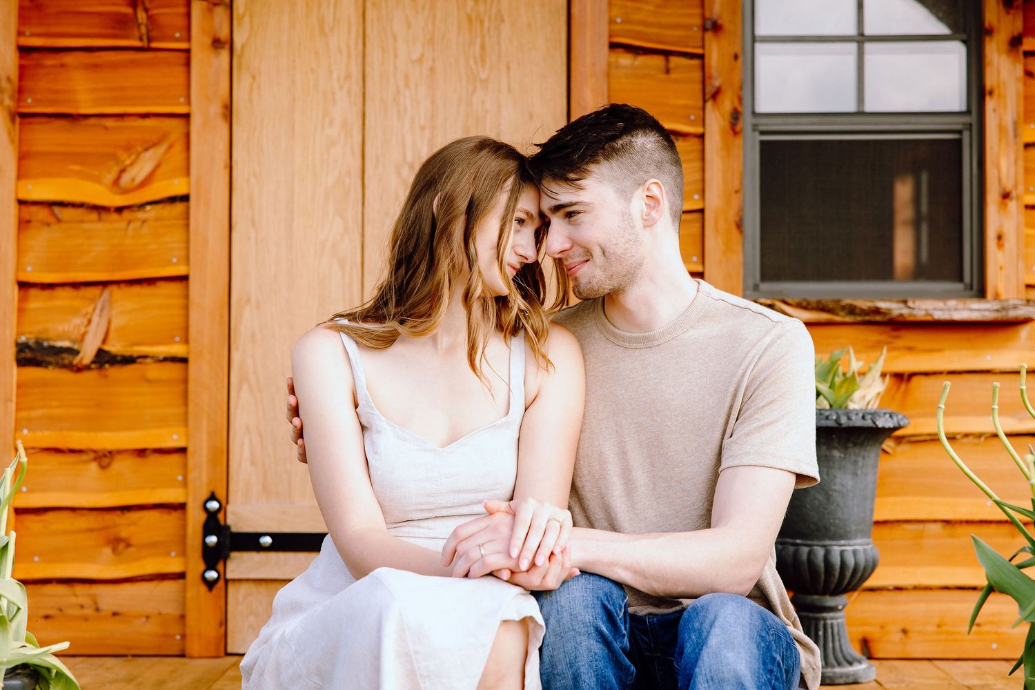 Engaged couple sitting on bench at DeBuck's tulip field spring engagement session in Belleville, MI