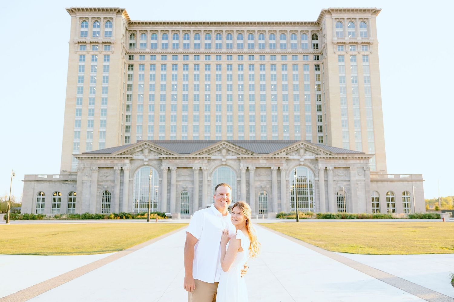 Engaged couple embracing at Michigan Central Station summer engagement session in Detroit, MI