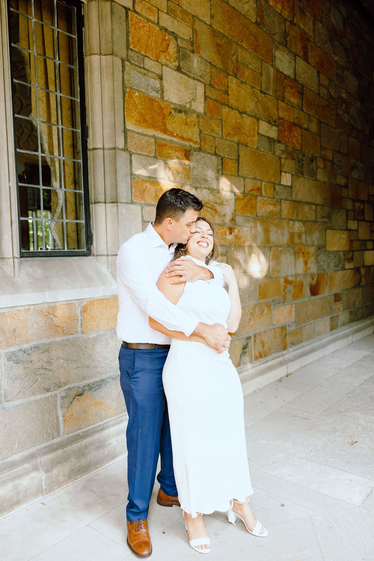 Engaged couple embracing at the University of Michigan Law Quad engagement session in Ann Arbor, MI