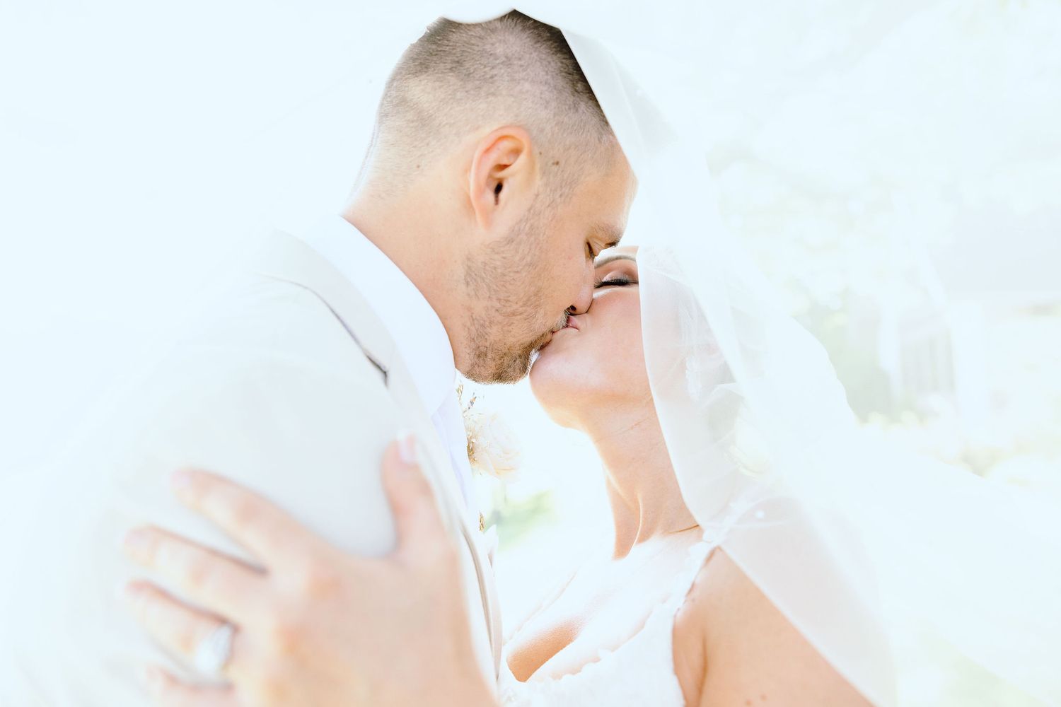 Married couple kissing under veil at Lapeer Country Club wedding in Michigan