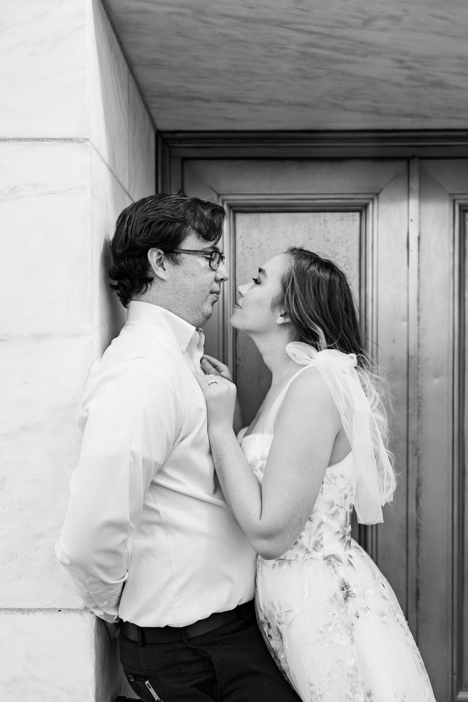 Engaged couple leaning against wall at Belle Isle summer engagement session in Detroit, MI