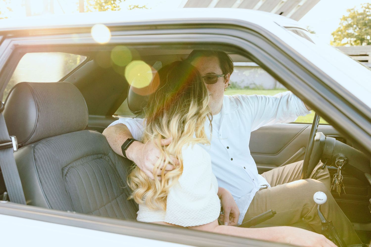 Engaged couple sitting in vintage car at Belle Isle summer engagement session in Detroit, MI