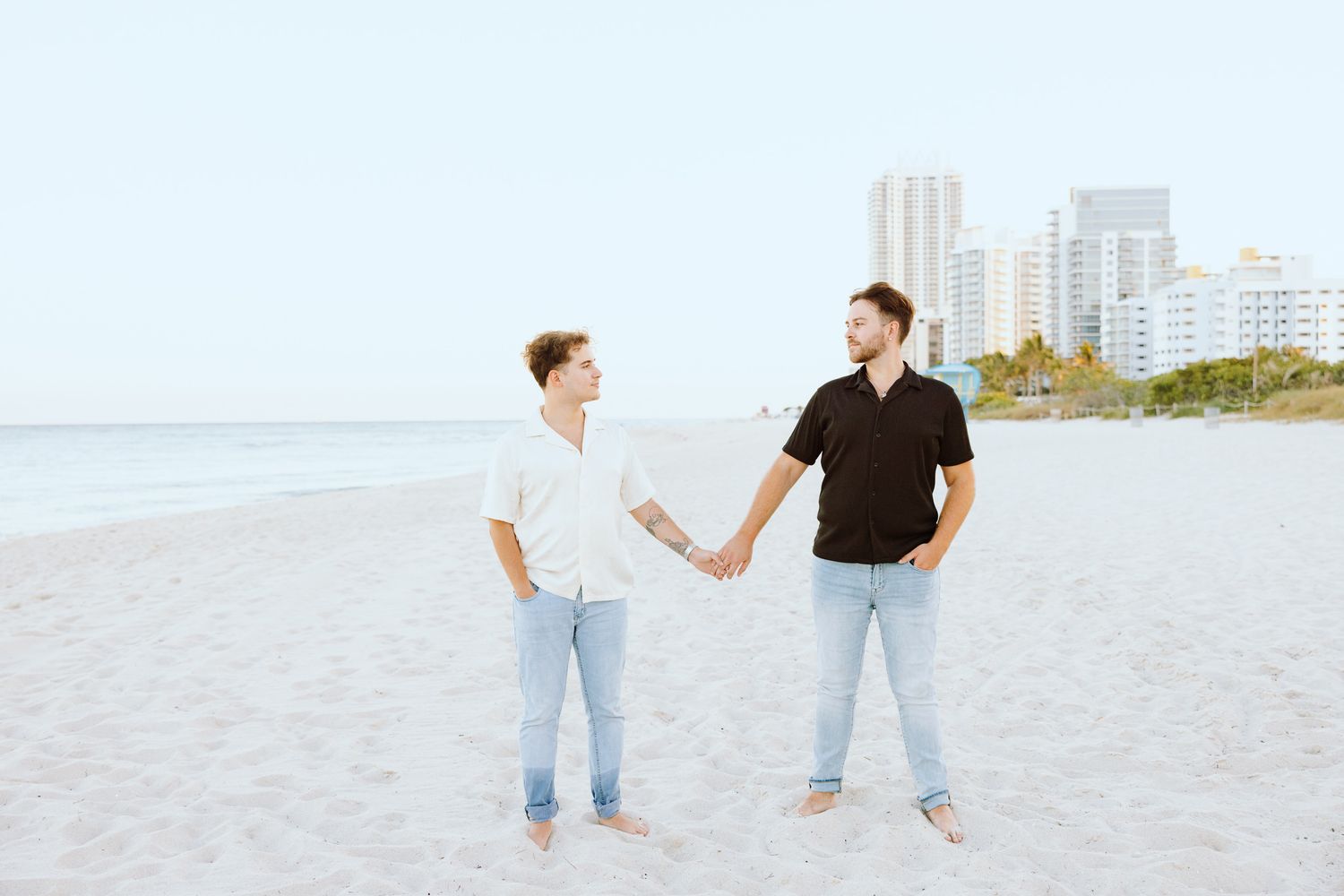Gay couple holding hands and looking at each other at North Miami Beach in Florida