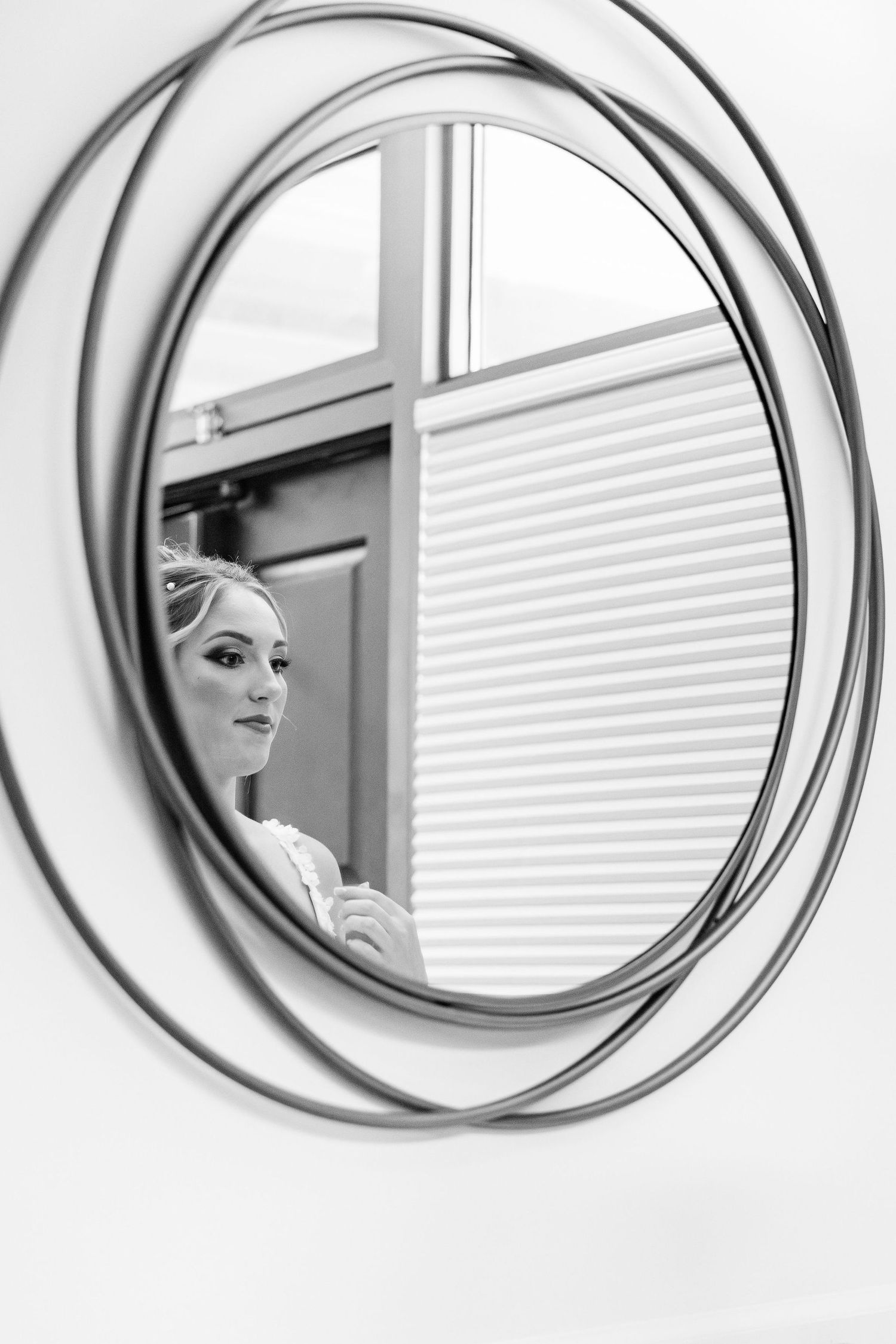 Bride looking into mirror at Lapeer Country Club wedding in Michigan