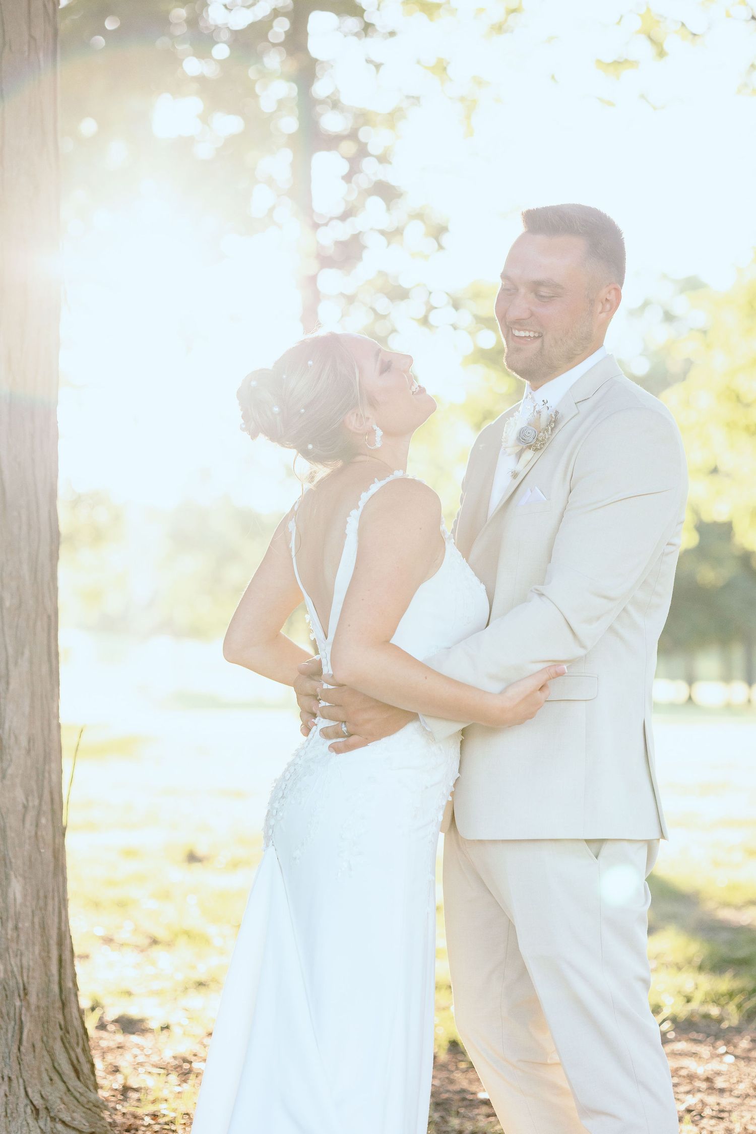 Married couple embracing during golden hour at Lapeer Country Club forest wedding in Michigan