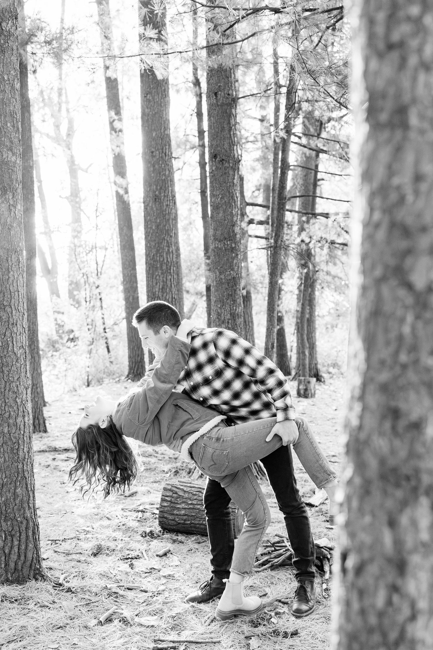 Engaged couple dipping in forest at Nichols Arboretum fall engagement session in Ann Arbor, MI