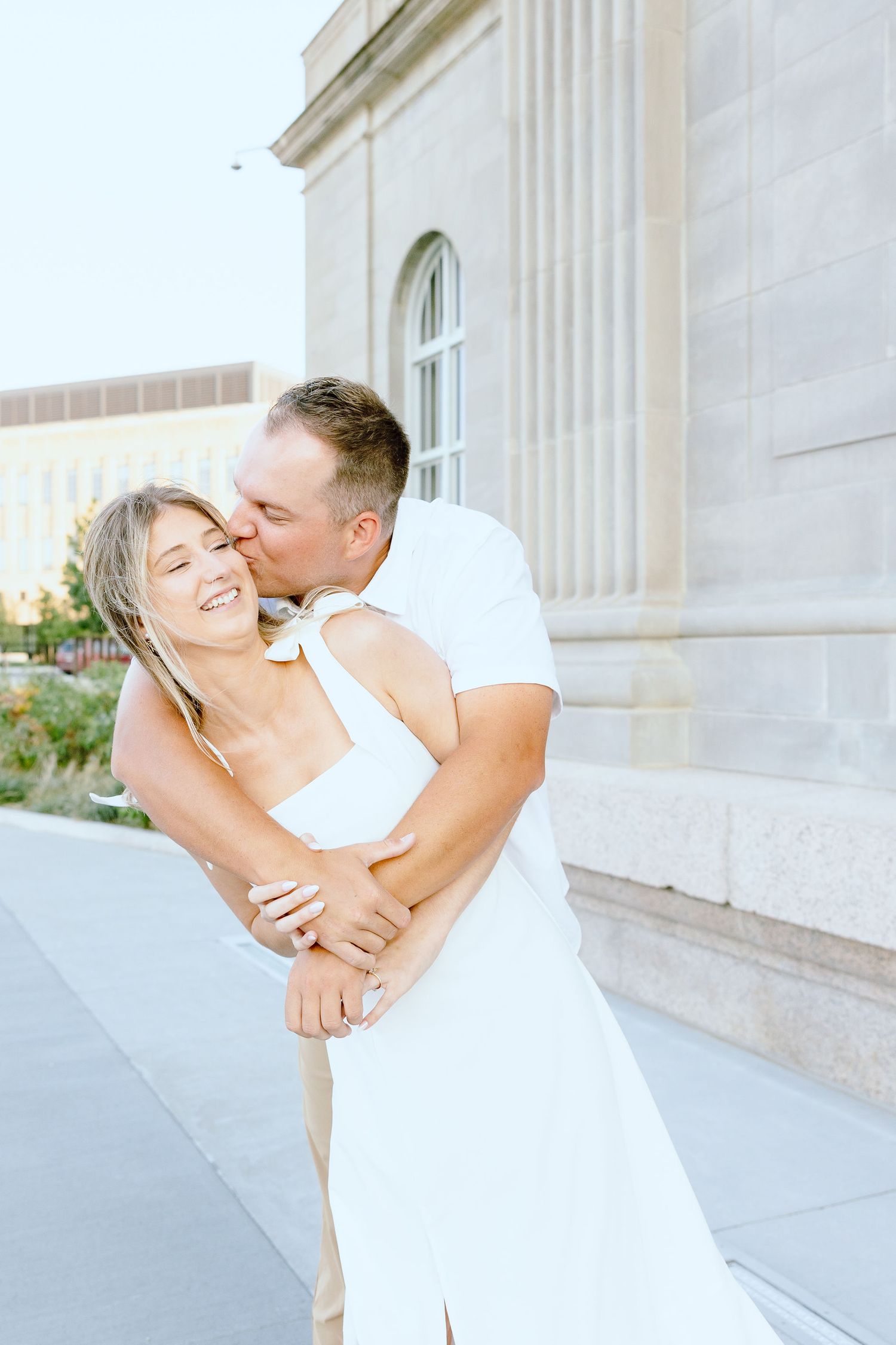 Engaged couple embracing at Michigan Central Station summer engagement session in Detroit, MI