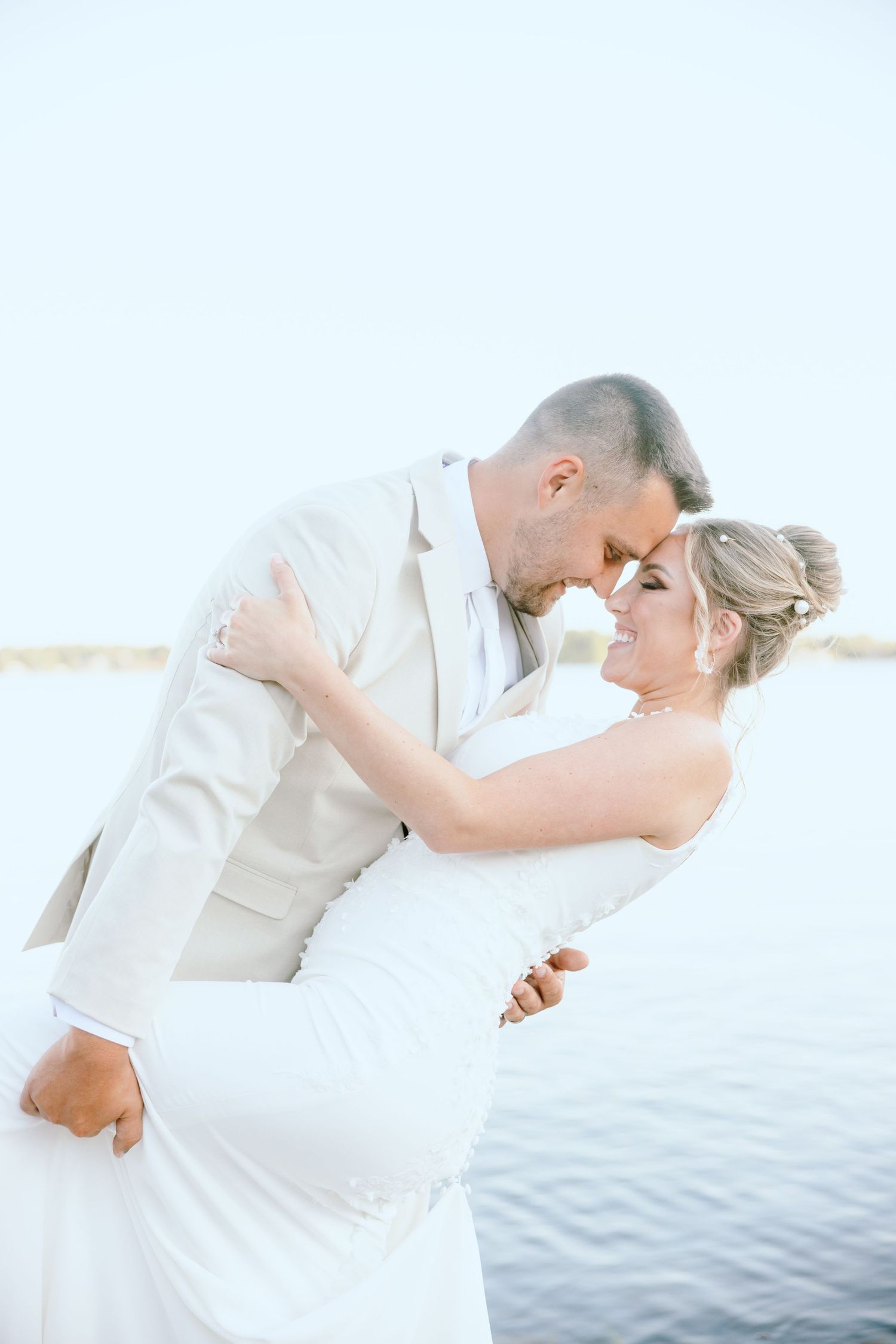Married couple dipping in front of lake in Lapeer, MI wedding