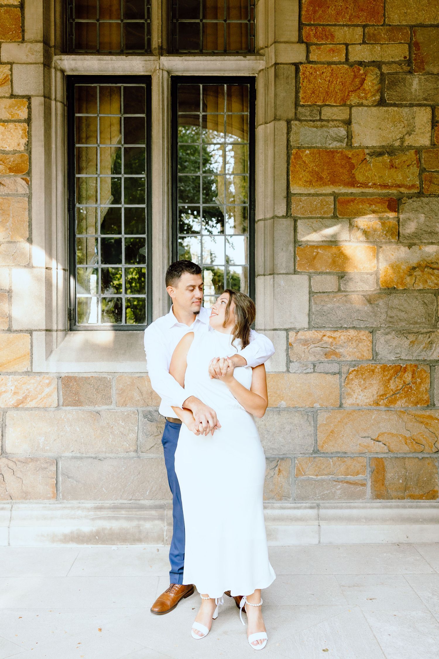 Engaged couple embracing at the University of Michigan Law Quad engagement session in Ann Arbor, MI