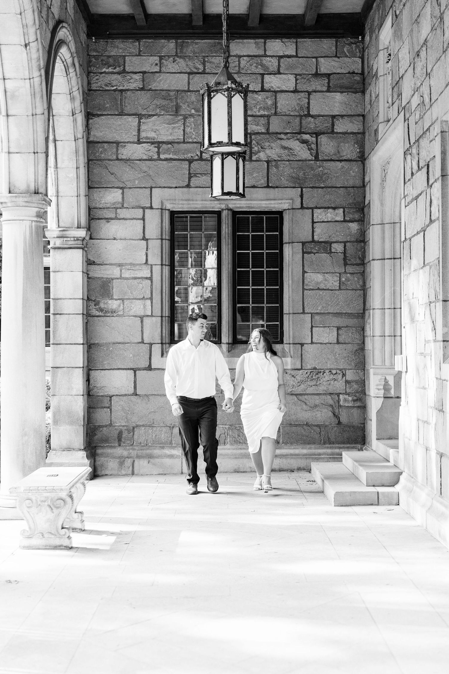 Engaged couple running and holding hands at the UofM Law Quad engagement session in Ann Arbor, MI