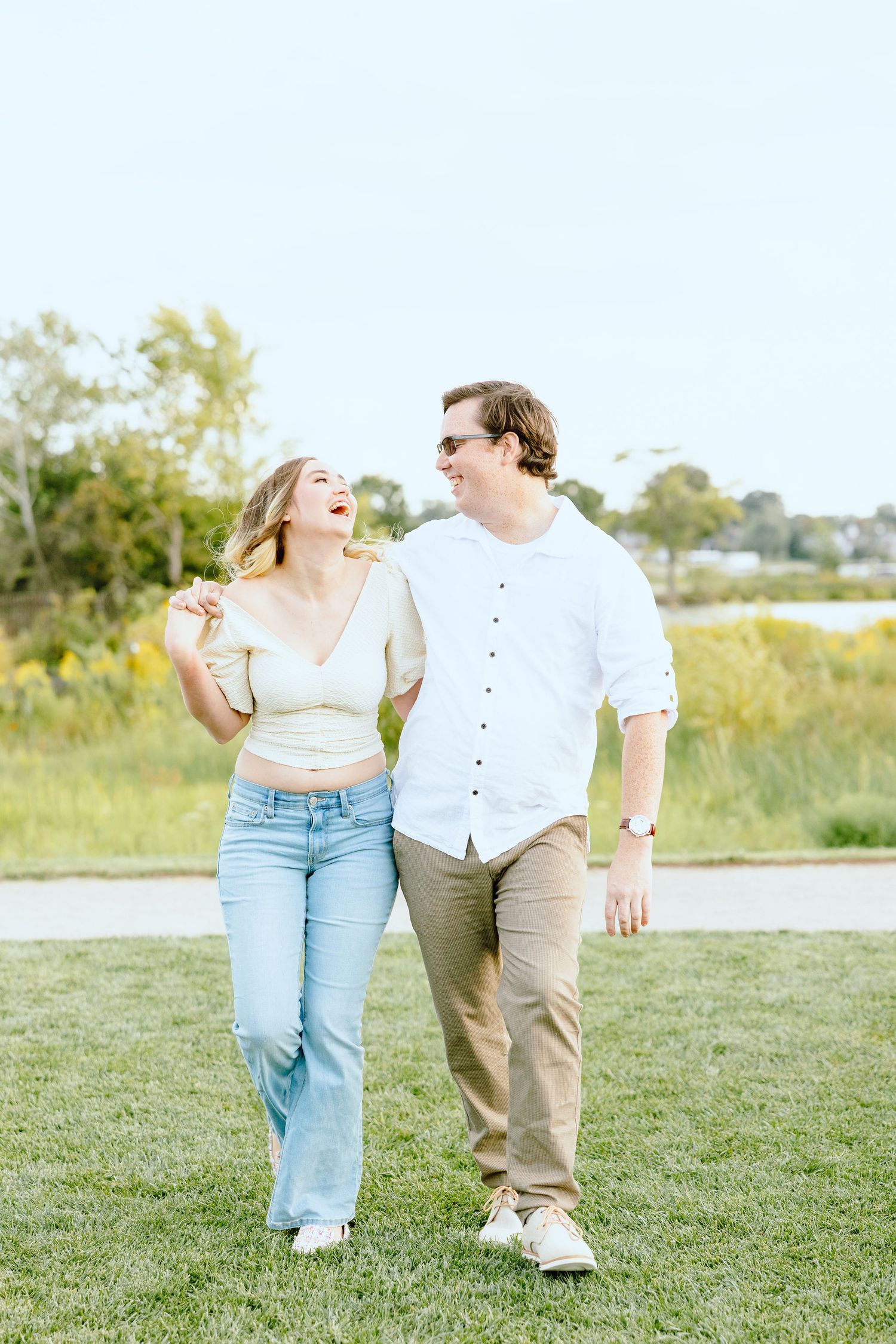 Engaged couple walking and holding hands at Belle Isle summer engagement session in Detroit, MI