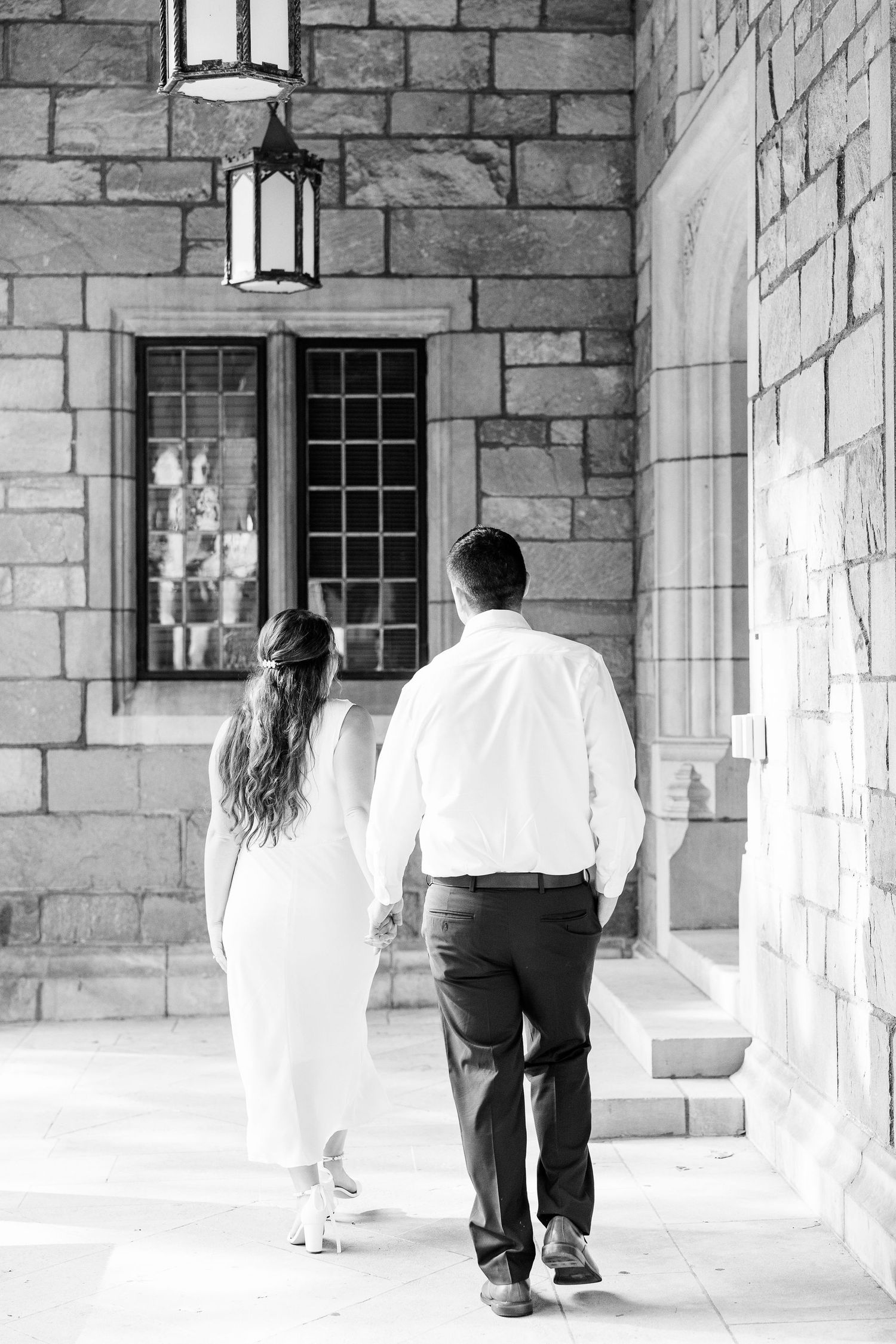 Engaged couple walking and holding hands at the UofM Law Quad engagement session in Ann Arbor, MI
