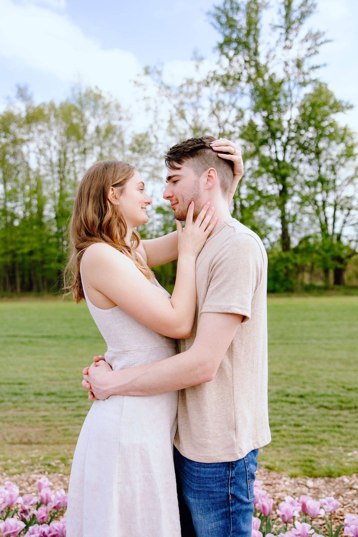 Engaged couple embracing at DeBuck's tulip field spring engagement session in Belleville, MI