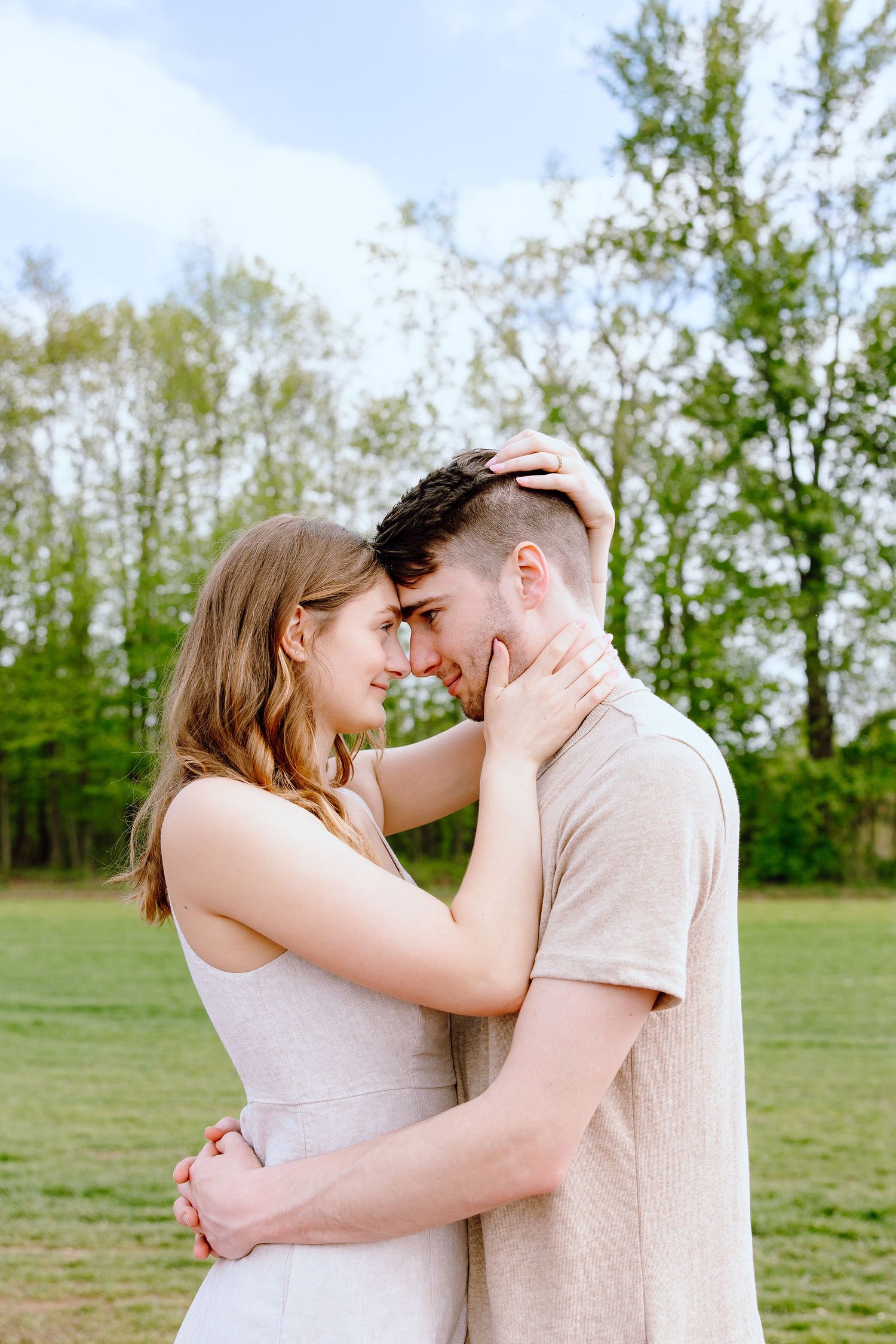 Engaged couple embracing at DeBuck's tulip field spring engagement session in Belleville, MI