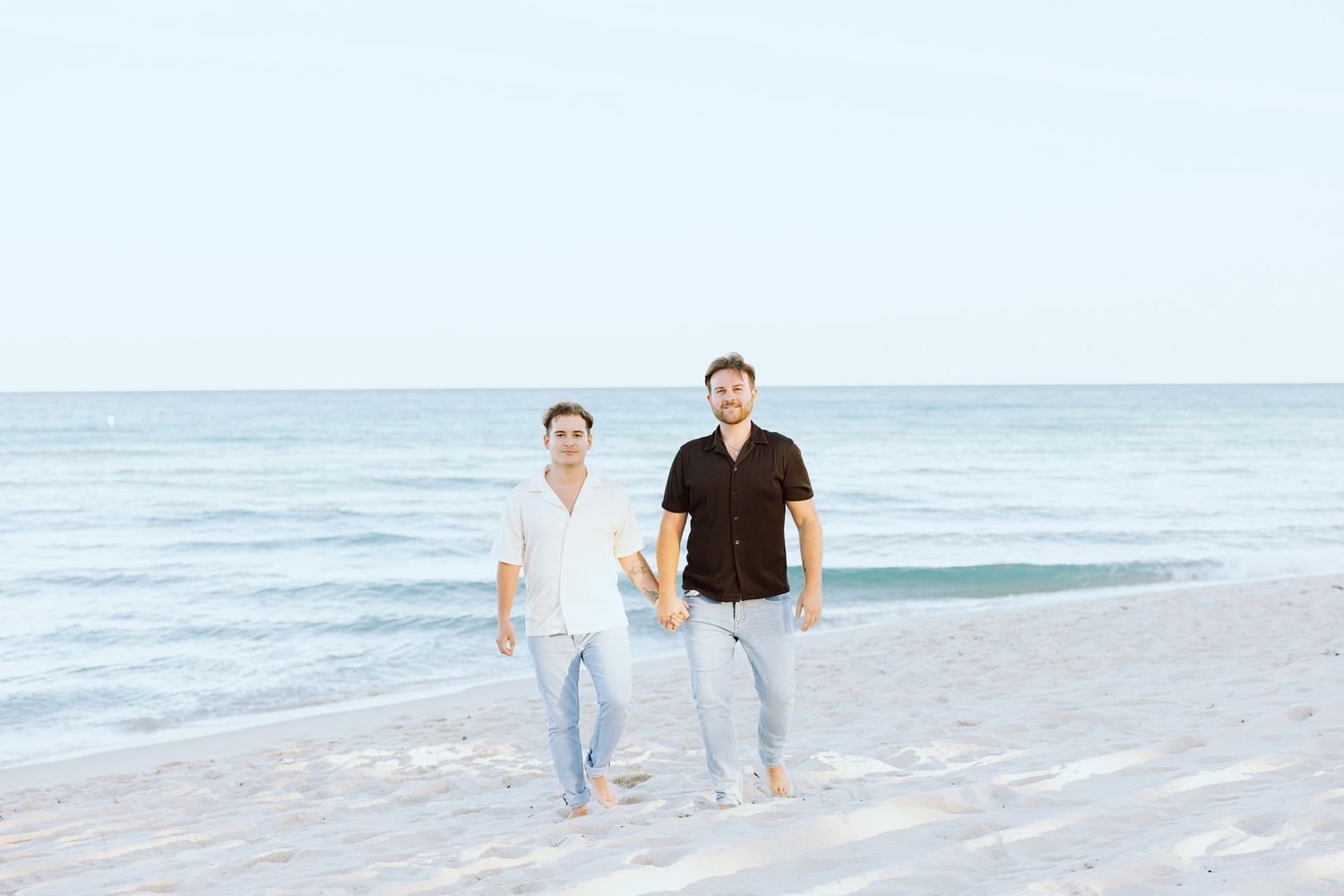 LGBTQ+ couple walking and holding hands on North Miami Beach in Florida