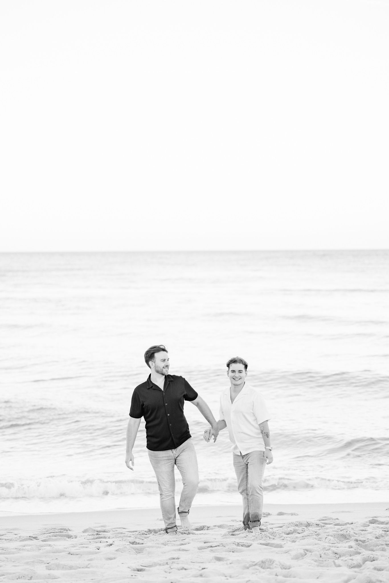 LGBTQ+ couple walking and holding hands on North Miami Beach in Florida