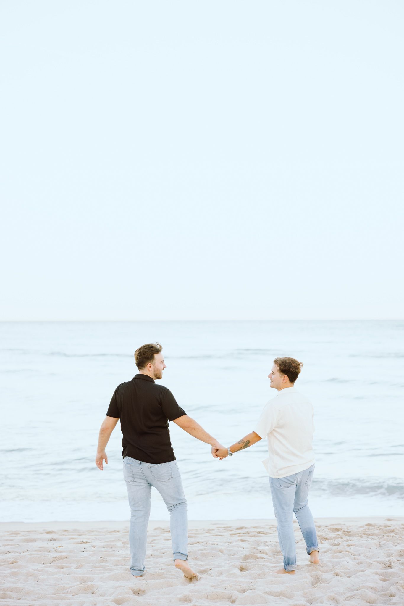LGBTQ+ couple walking and holding hands on North Miami Beach in Florida