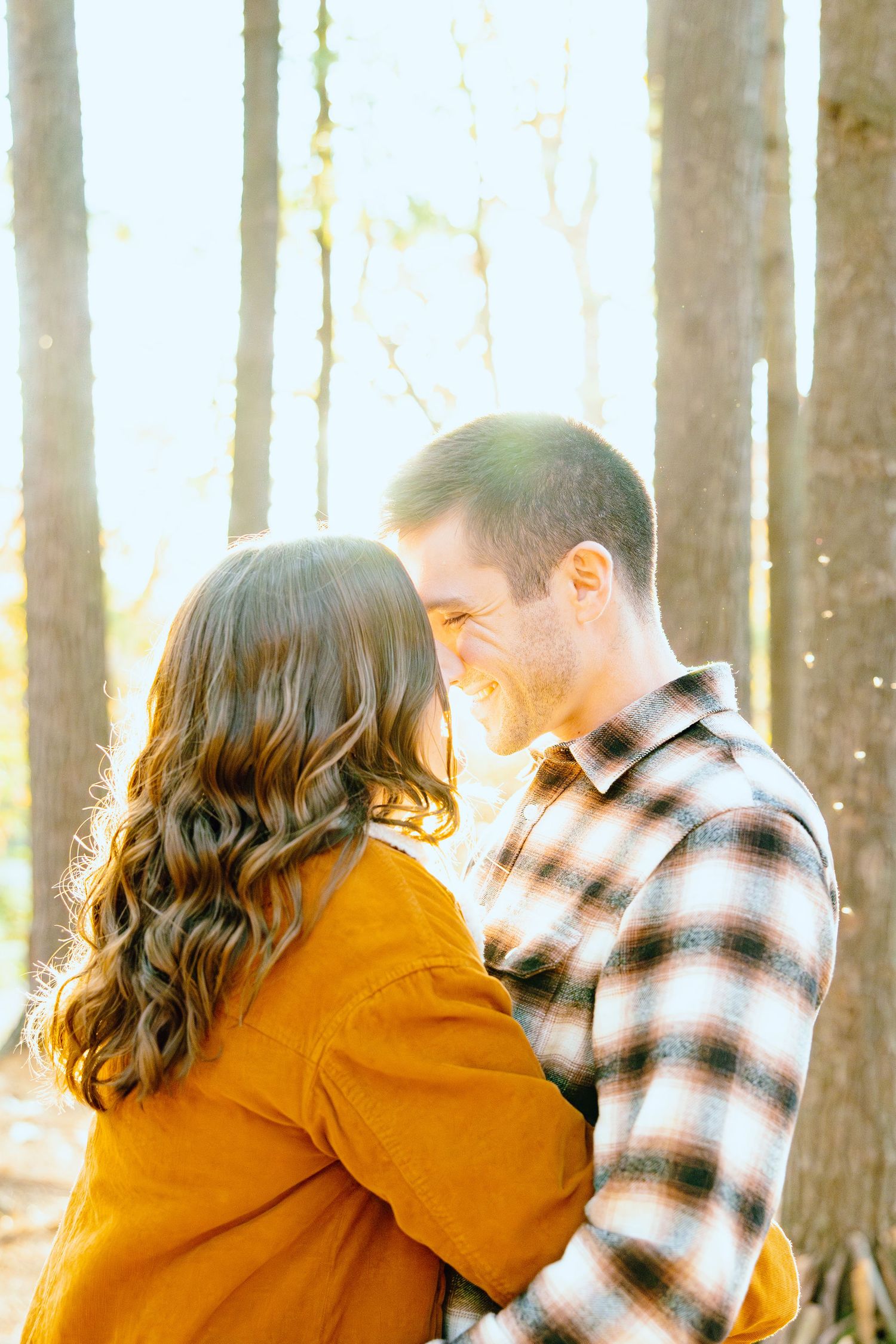 Engaged couple embracing in forest at Nichols Arboretum fall engagement session in Ann Arbor, MI
