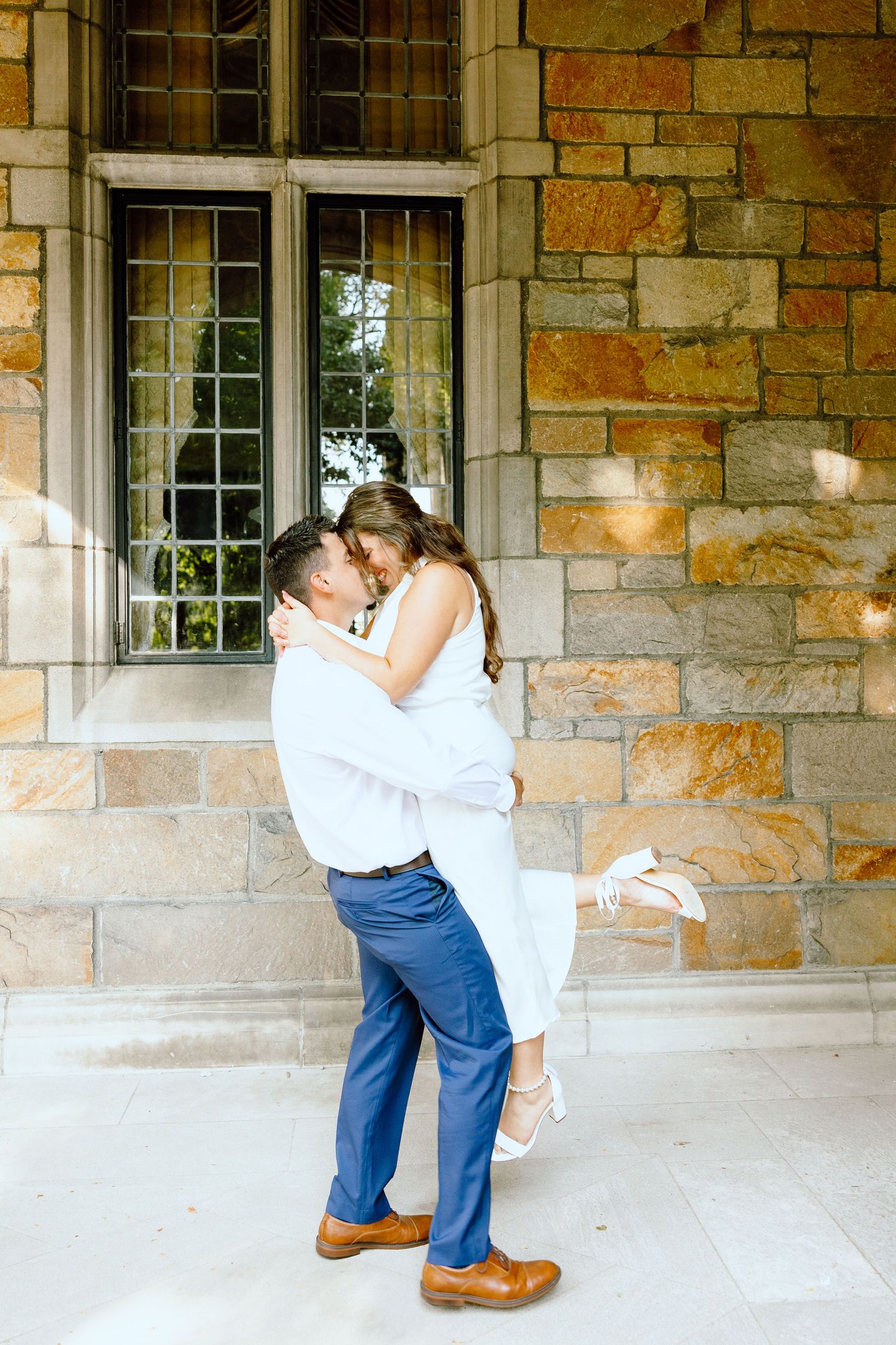 Man lifting woman at the UofM Law Quad engagement session in Ann Arbor, MI